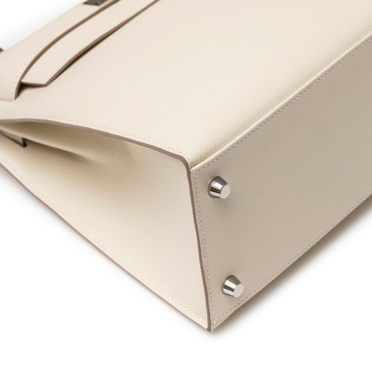 Close-up of bottom corner and silver feet on Hermès Kelly 28 Sellier Craie Epsom Palladium Hardware handbag