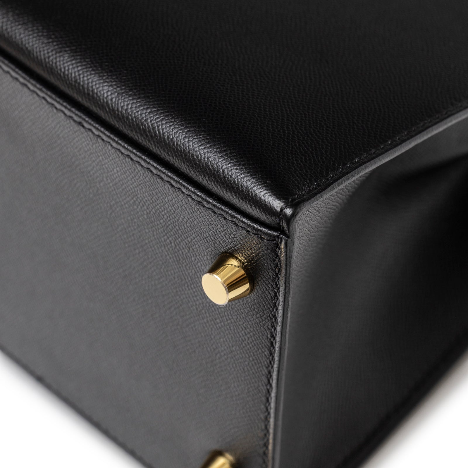 Close-up of Hermès Kelly 28 Sellier Touch Black Madame Shiny Niloticus Crocodile Gold Hardware bottom corner with gold stud detail