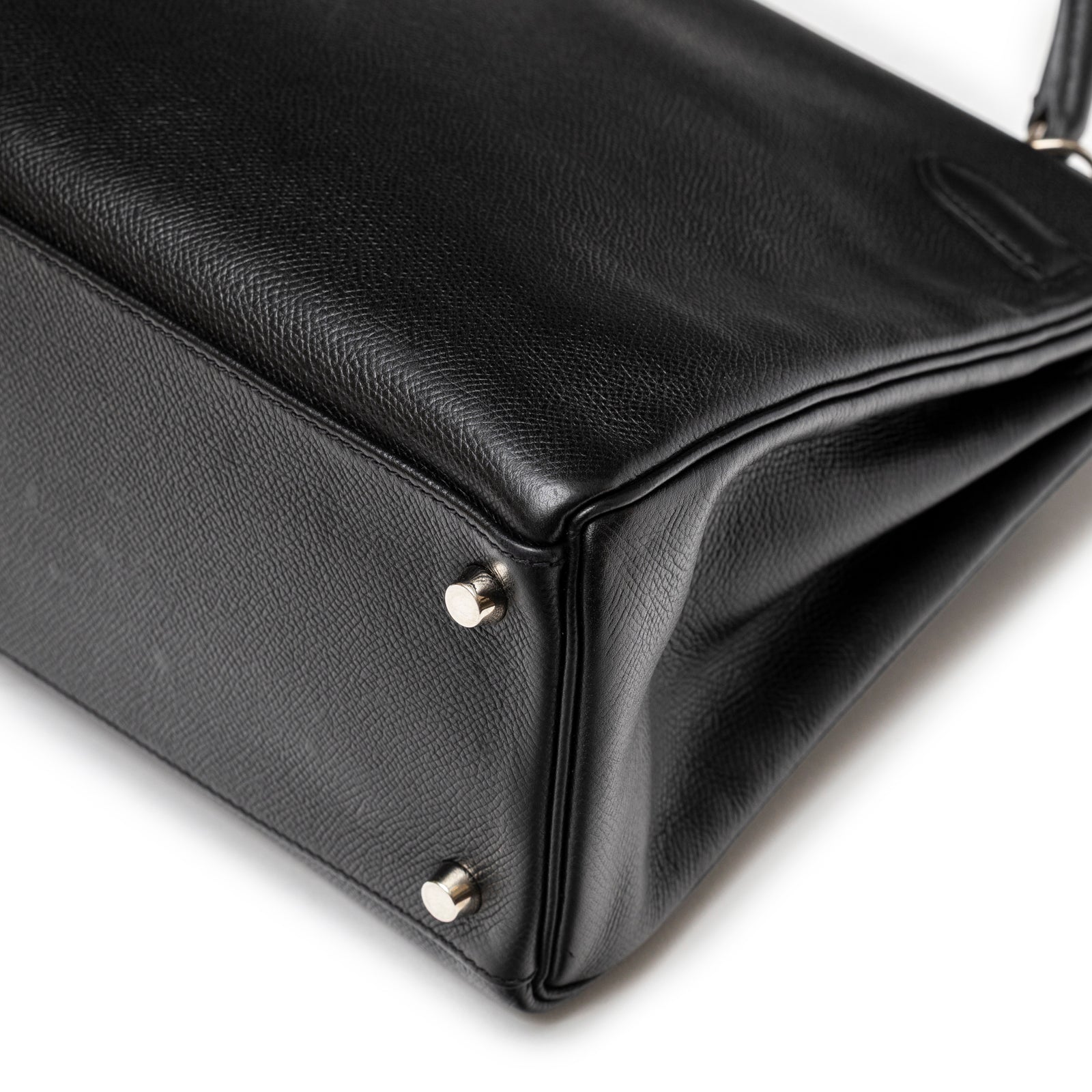Bottom corner close-up of Hermès Kelly 32 Black Epsom Palladium Hardware showing smooth leather and metal studs