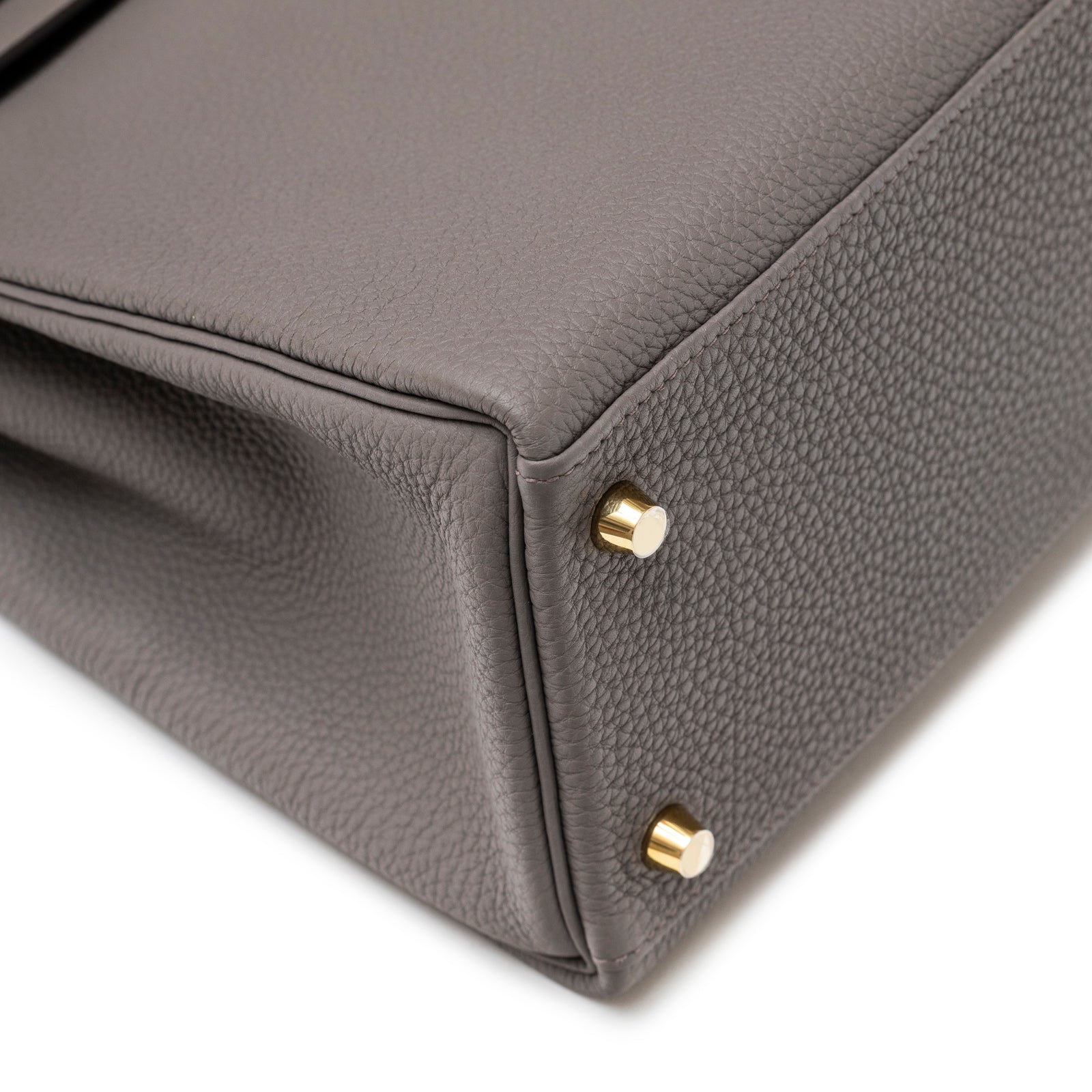 Close-up of bottom corner showing Etain Togo leather texture and gold hardware feet on Hermès Kelly 32 Retourne Etain Togo Gold Hardware