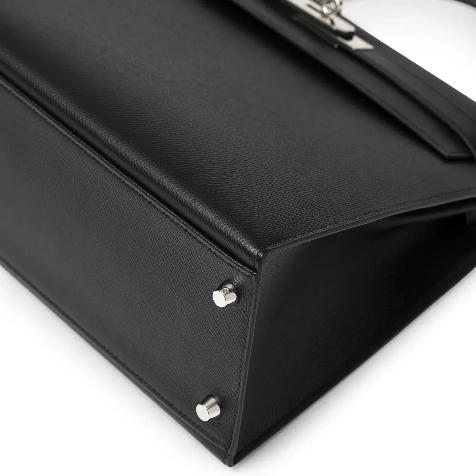 Close-up bottom view of Hermès Kelly 32 Sellier Black Epsom Palladium Hardware bag showing metal feet and leather texture