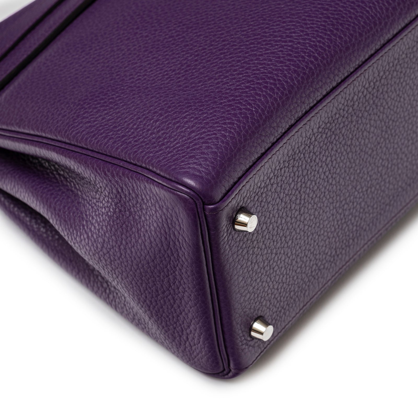 Close-up of bottom corner showing textured violet leather and shiny palladium feet on Hermès Kelly 32 Violet Togo Palladium Hardware