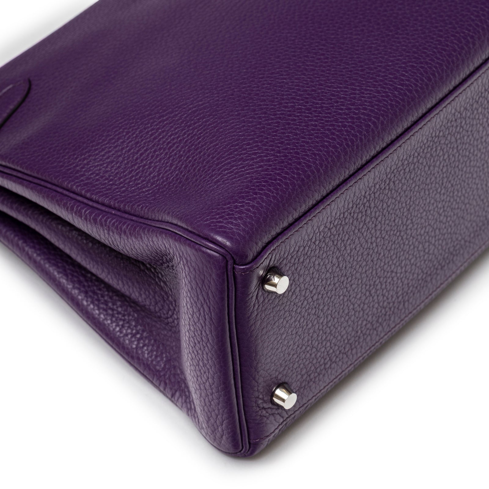 Close-up of purple textured leather corner and silver metal protective feet on Hermès Kelly 32 Violet Togo Palladium Hardware handbag