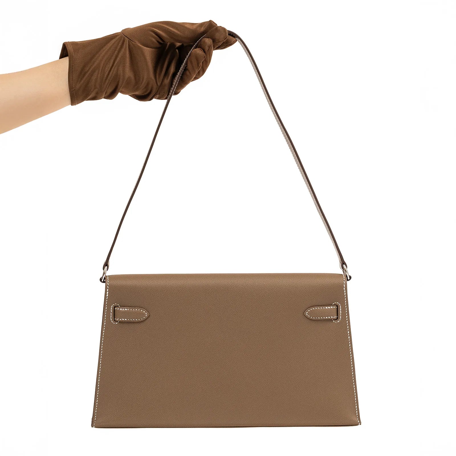 Back view of Hermès Kelly Elan Etoupe Madame Palladium Hardware showing clean stitching and slim strap held by gloved hand
