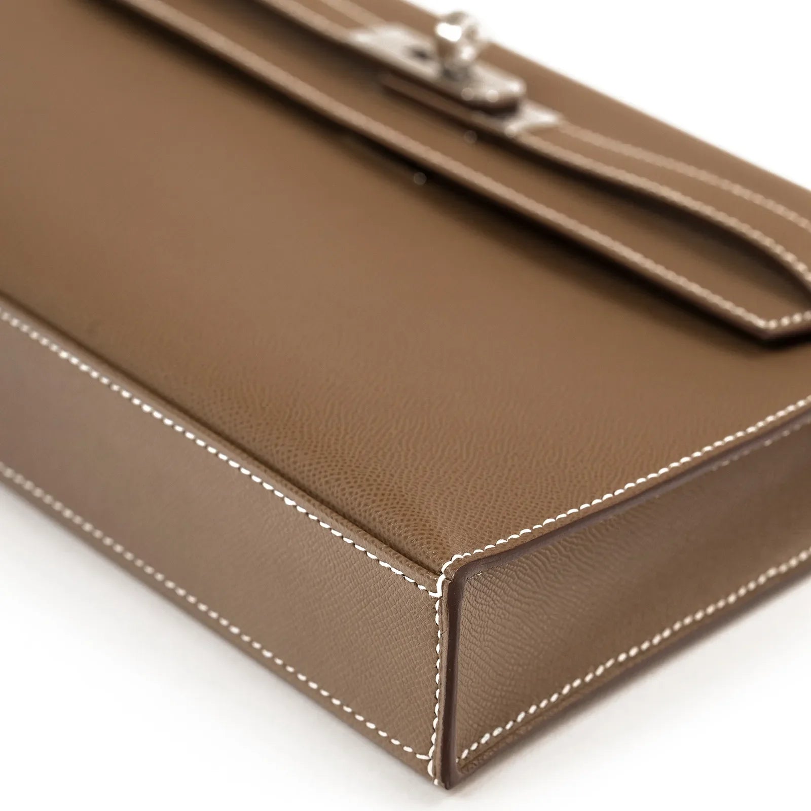 Close-up of stitching detail and textured leather on Hermès Kelly Elan Etoupe Madame Palladium Hardware bag bottom corner