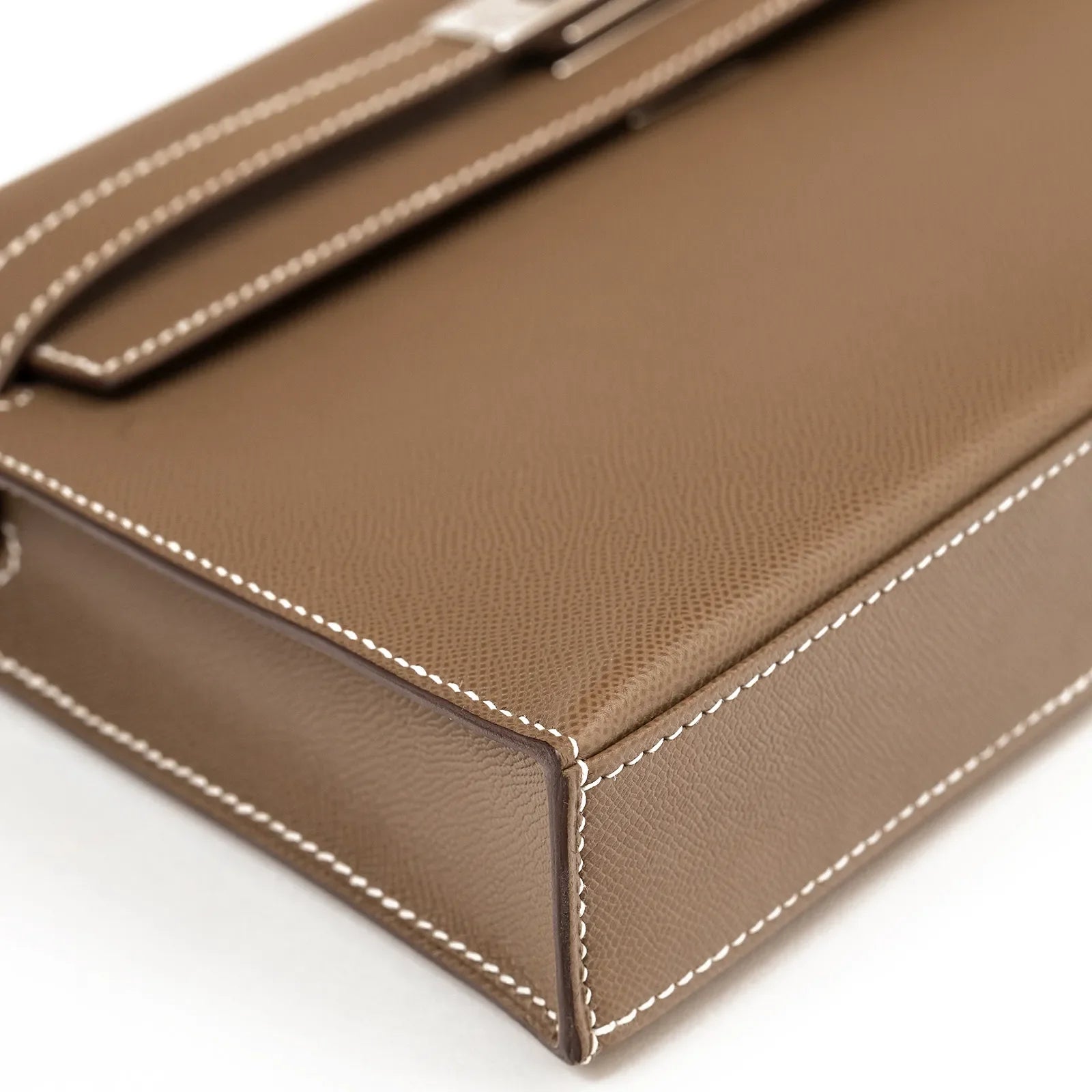 Close-up angled view of Hermès Kelly Elan Etoupe Madame Palladium Hardware showing textured leather and white stitching detail