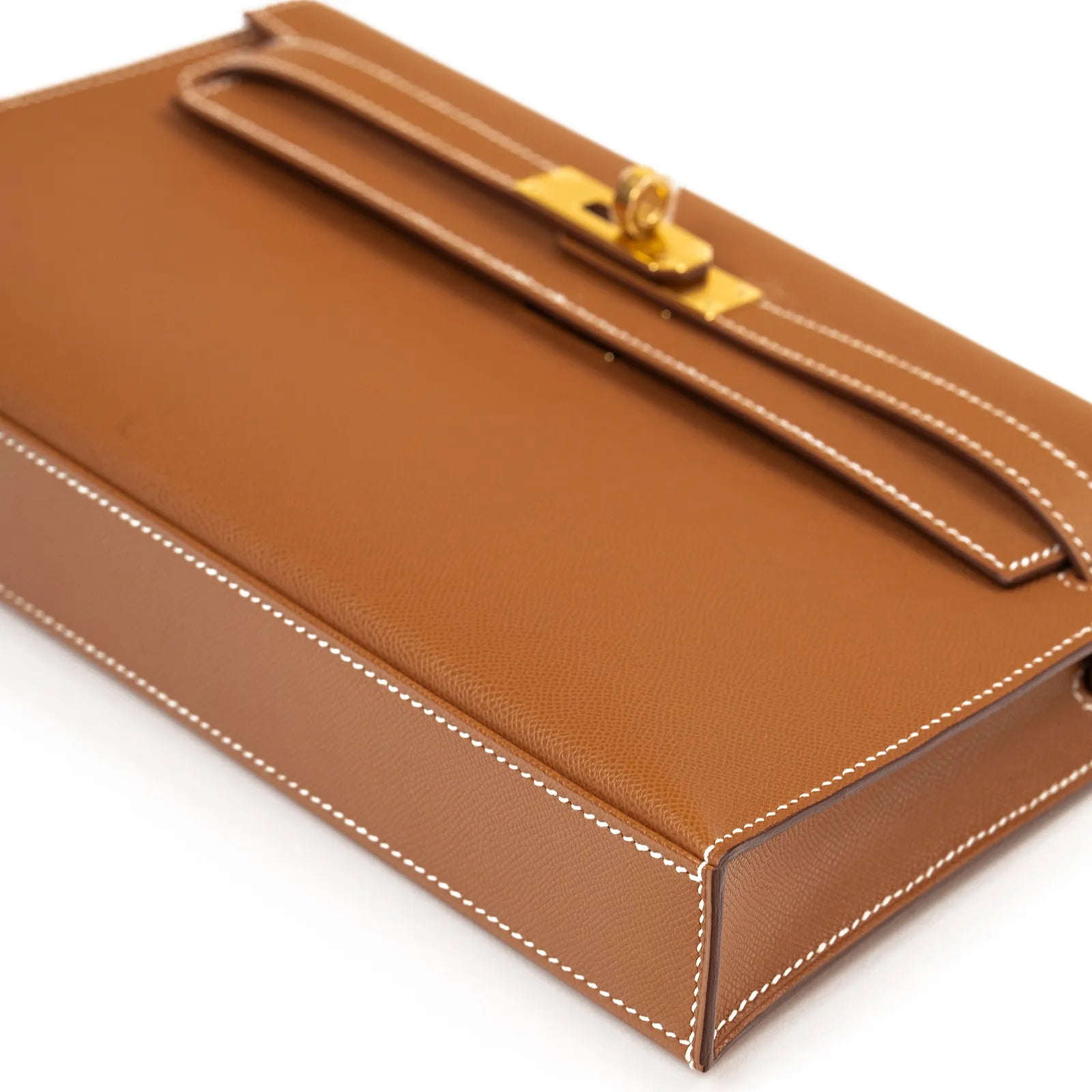 Angled bottom view of Hermès Kelly Elan Gold Madame Gold Hardware in smooth tan leather with white stitching detail