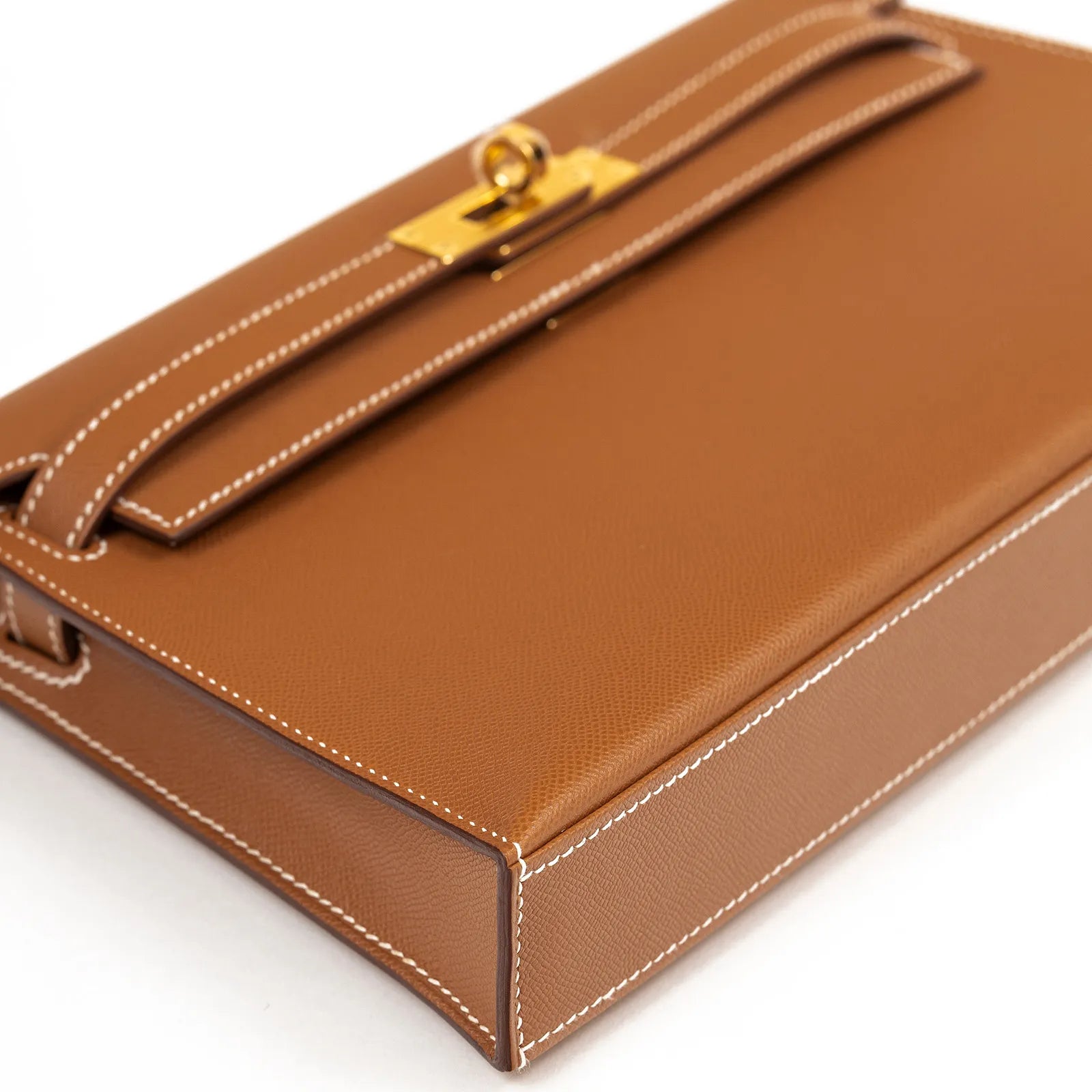 Angled close-up of Hermès Kelly Elan Gold Madame Gold Hardware showing textured leather and white stitching details