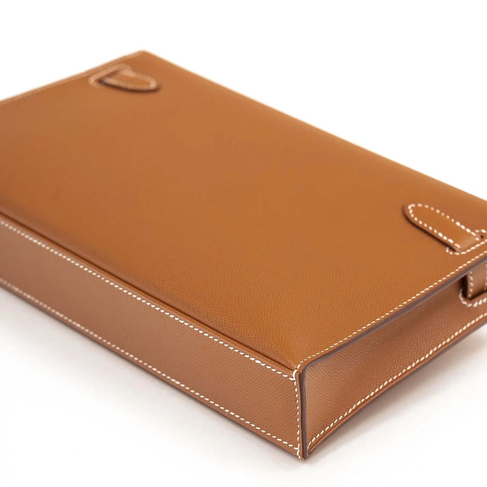 Close-up bottom view of Hermès Kelly Elan Gold Madame Gold Hardware showcasing leather texture and white stitching detail