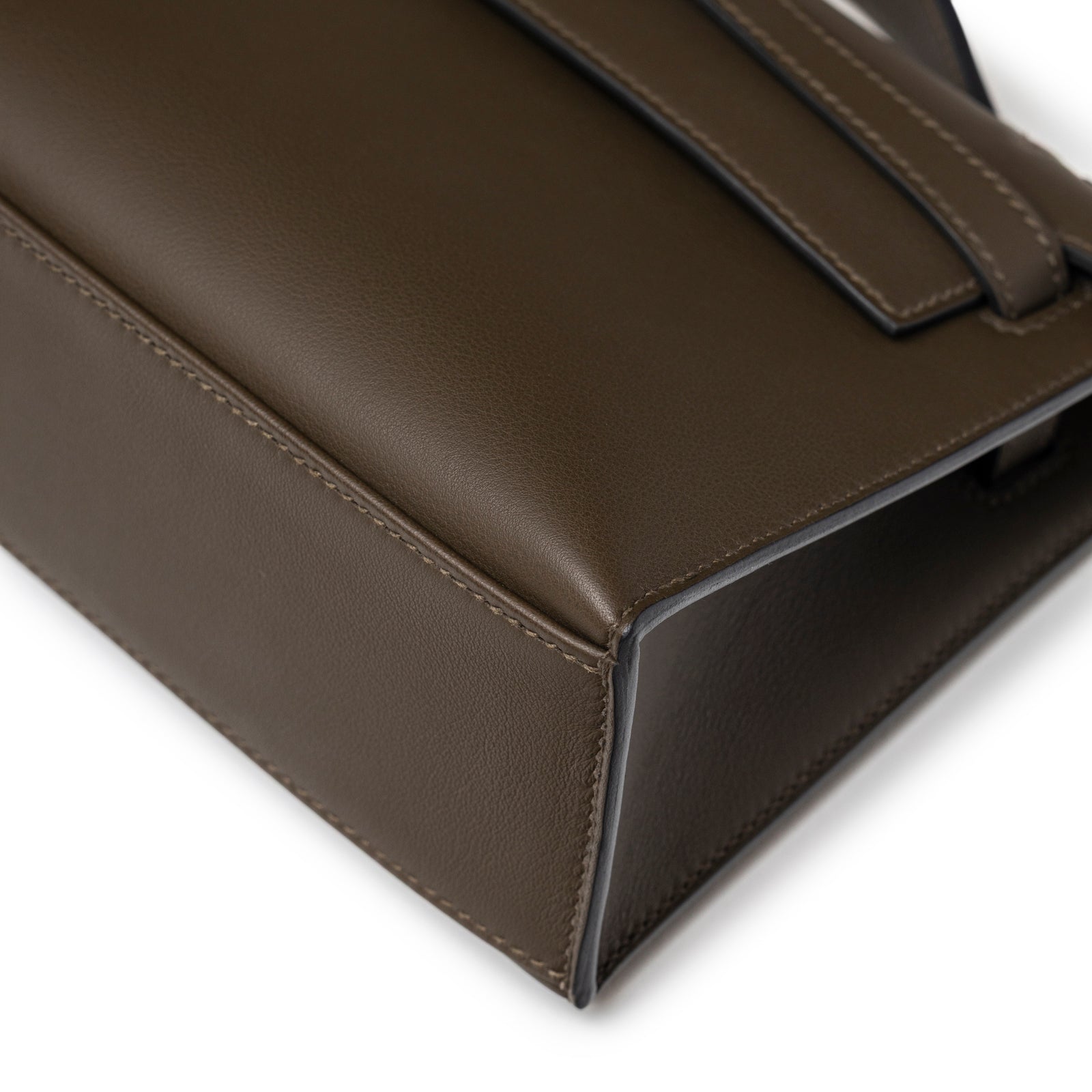 Close-up angled view of Hermès Kelly Pochette Vert Loden Swift Permabrass Hardware corner stitching detail