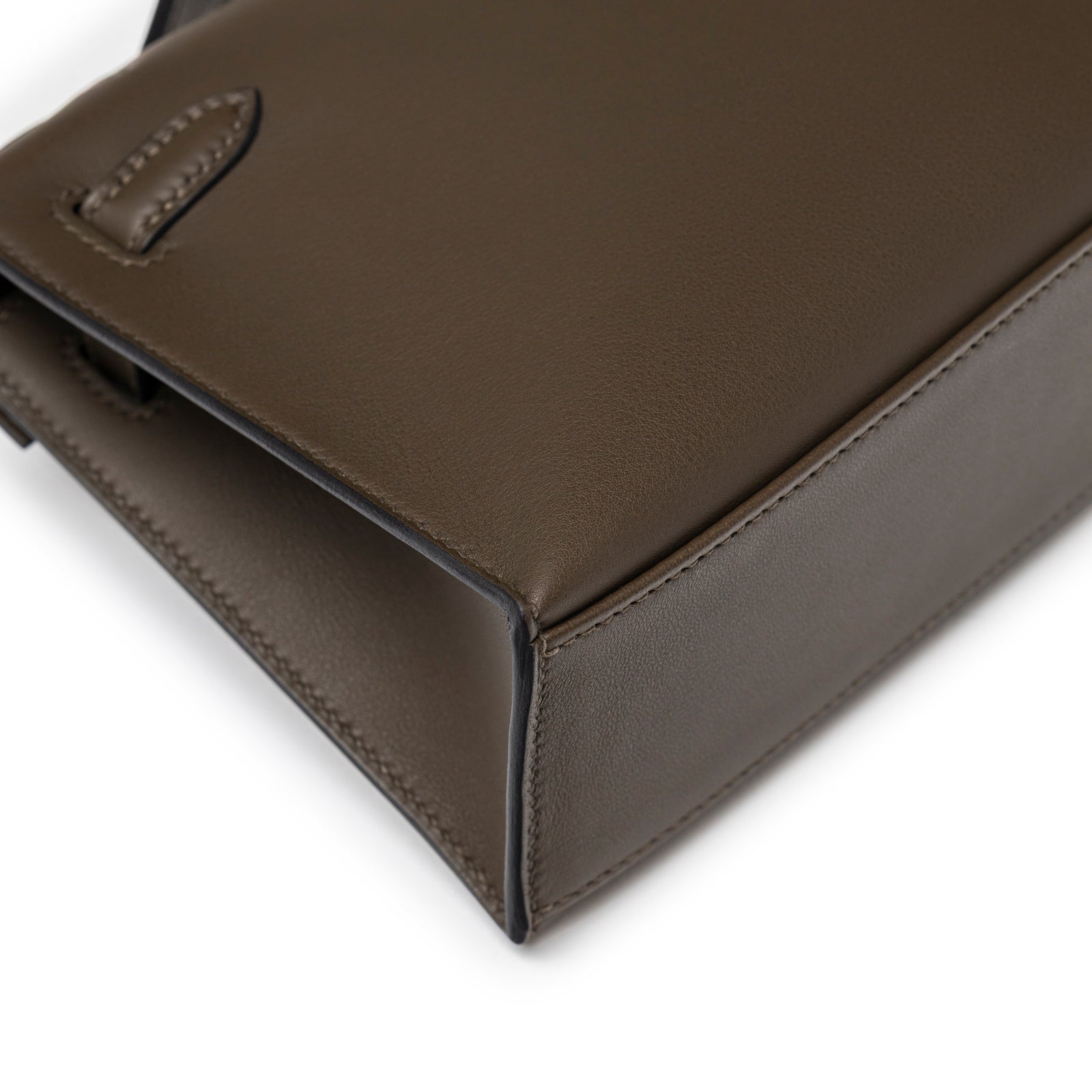 Close-up angle of Hermès Kelly Pochette Vert Loden Swift Permabrass Hardware corner and stitching detail