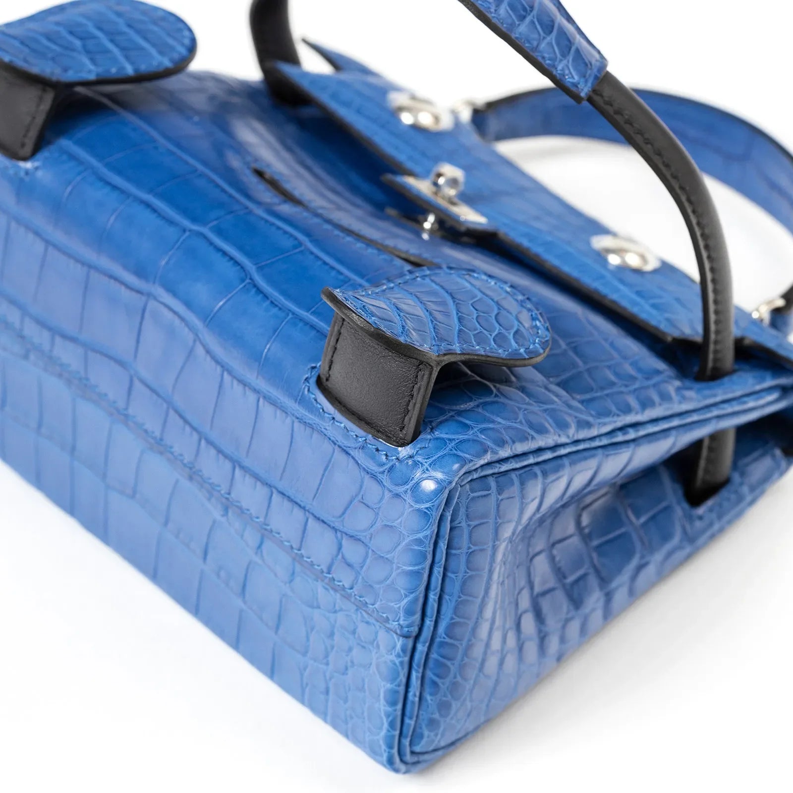 Close-up angled view of Hermès Kelly Quelle Idole Doll Bag AB Bleu Zellige/Bleu Indigo Palladium Hardware showcasing croc texture and stitching detail