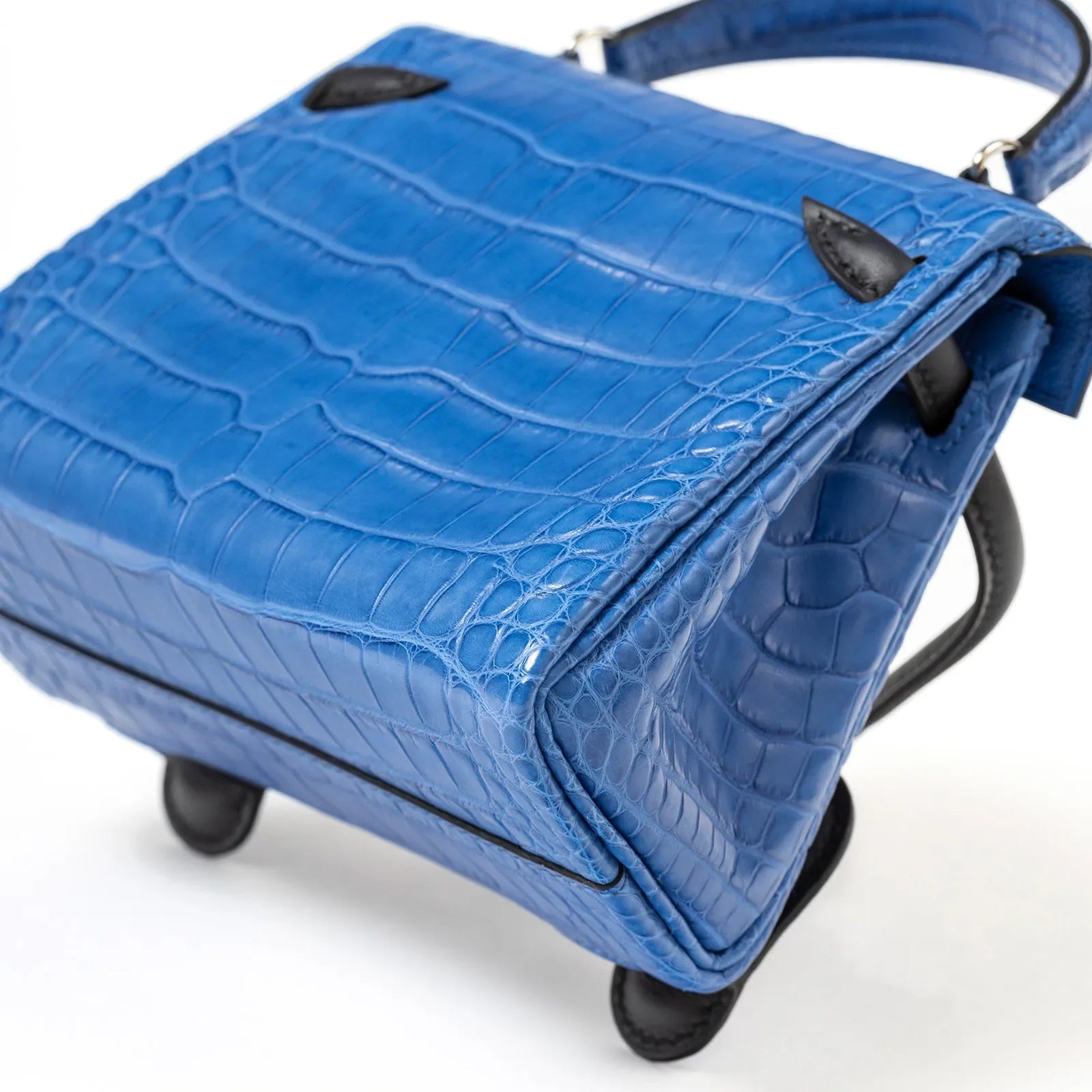 Close-up bottom view of Hermès Kelly Quelle Idole Doll Bag AB Bleu Zellige/Bleu Indigo Palladium Hardware showing blue crocodile texture