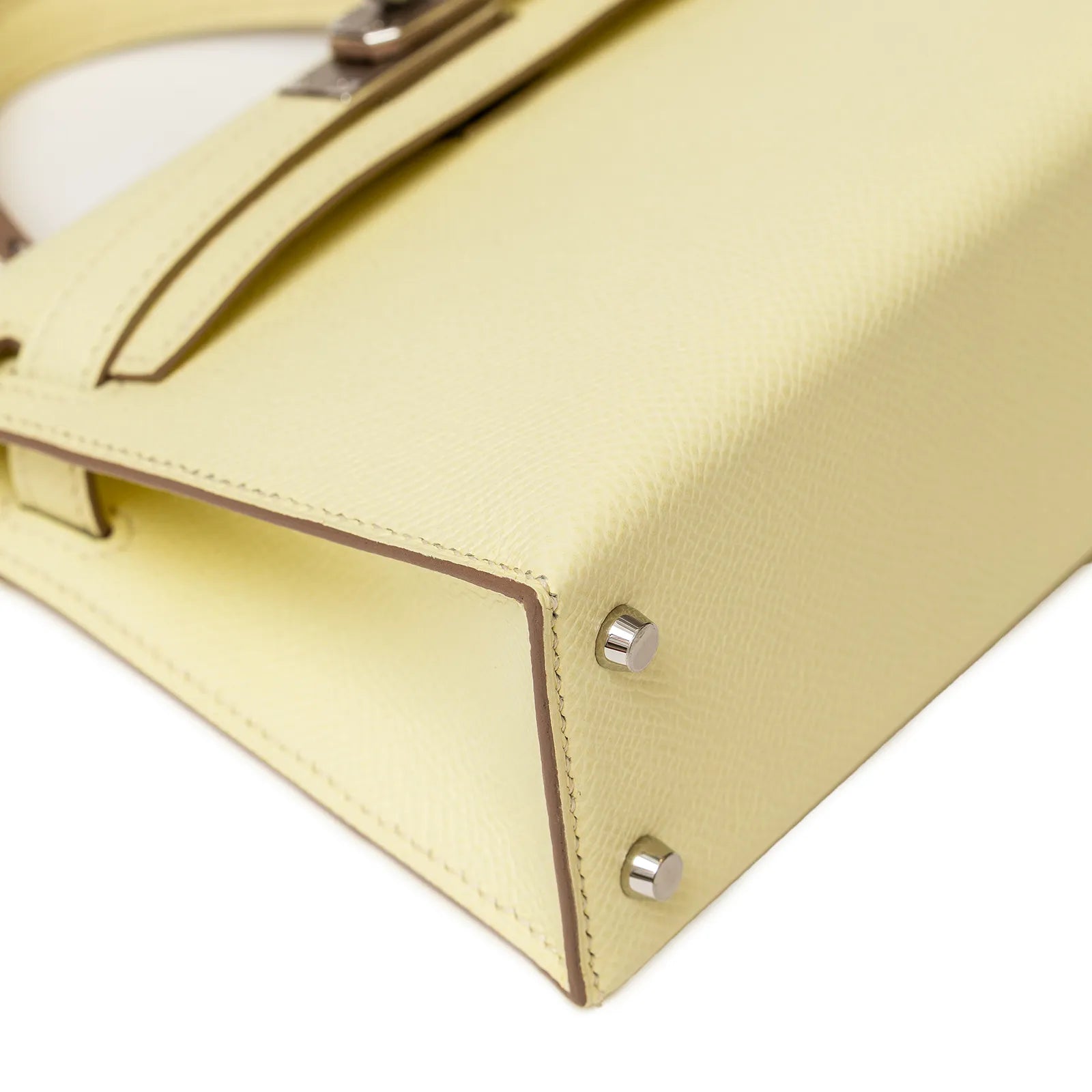 Close-up of bottom corner showing palladium hardware and textured Epsom leather on Hermès Mini Kelly II Sellier 20 Jaune Milton Epsom Palladium Hardware