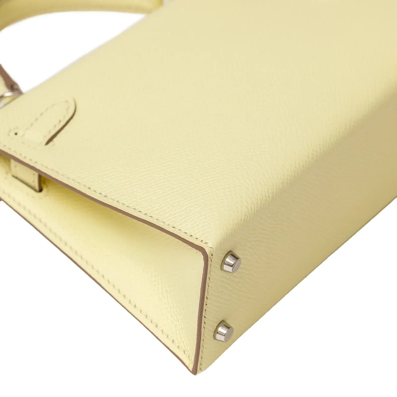 Close-up angled shot of Hermès Mini Kelly II Sellier 20 Jaune Milton Epsom Palladium Hardware corner detailing