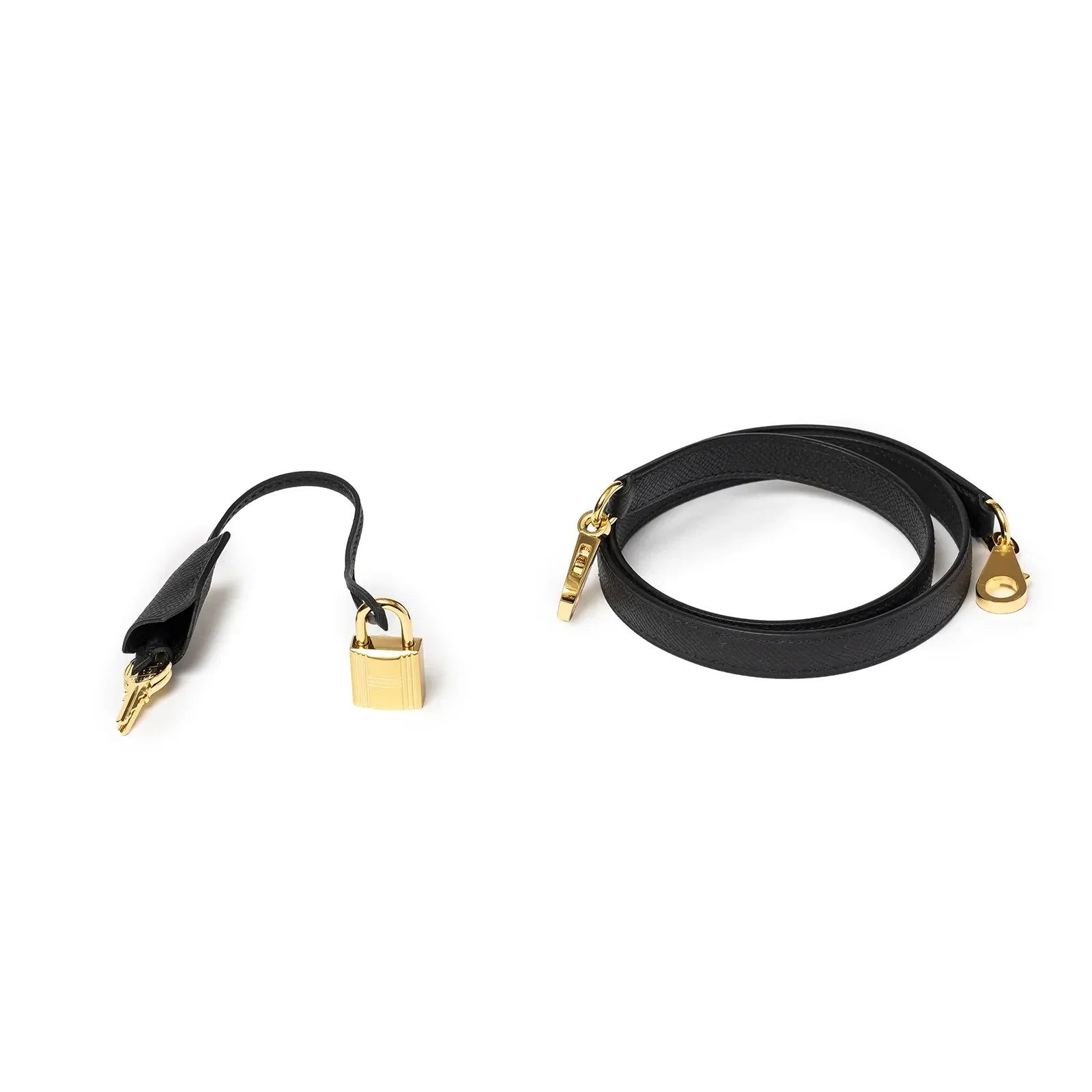 Close-up of Hermès Kelly 28 Sellier Black Epsom Gold Hardware strap and padlock accessories on white background