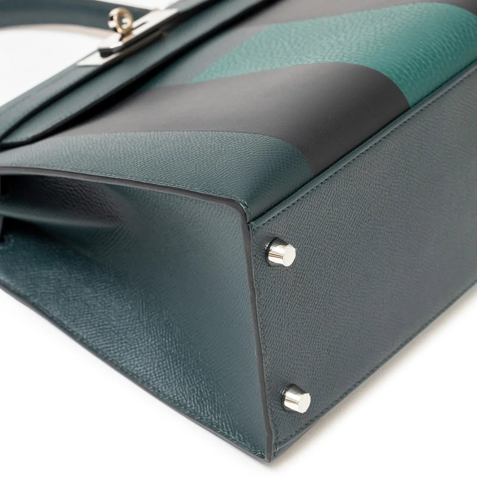 Close-up bottom corner view of Hermès Kelly 28 Sellier Lettre H Vert Cypress/Bleu Obscur/Malachite Veau Epsom Palladium Hardware showing texture and feet