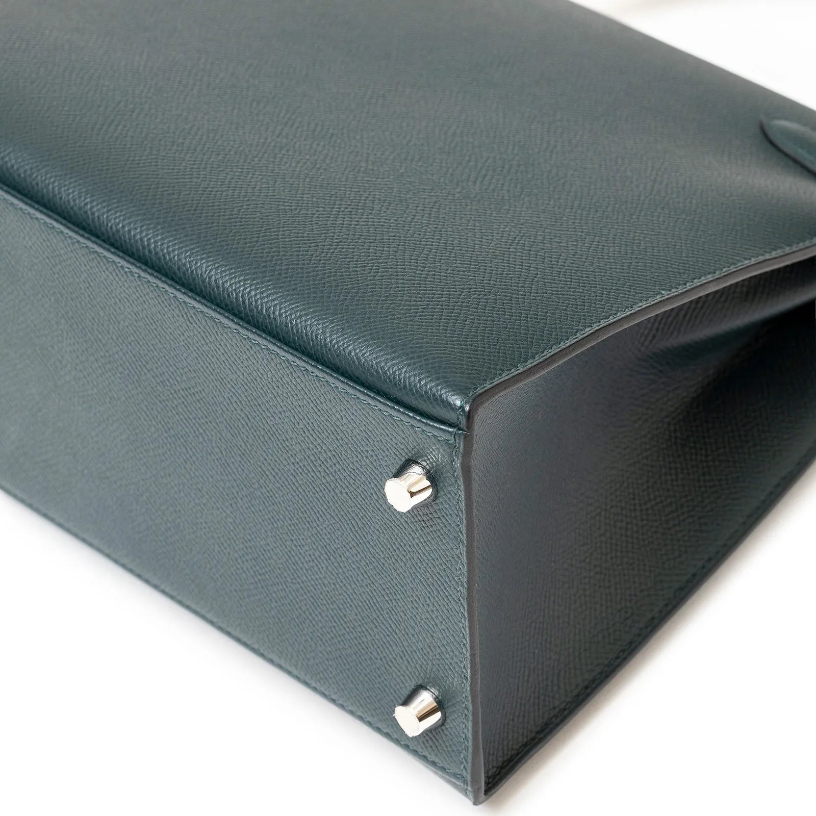 Close-up bottom view of Hermès Kelly 28 Sellier Lettre H Vert Cypress/Bleu Obscur/Malachite Veau Epsom Palladium Hardware showing leather texture and protective feet
