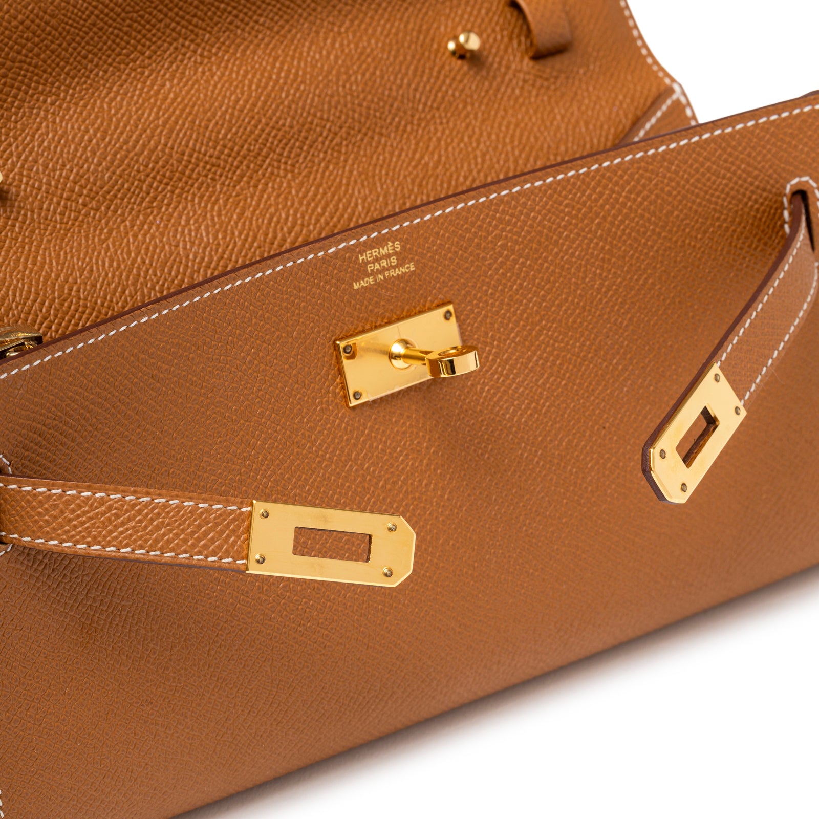 Close-up of front lock and gold hardware on Hermès Kelly Wallet To Go Gold Epsom Gold Hardware showing leather texture