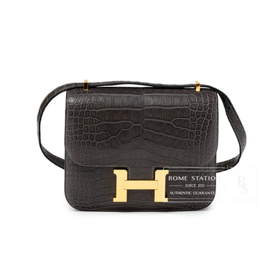 Front view of Hermès Mini Constance 18 Graphite Matte Alligator Gold Hardware with signature H clasp and textured leather