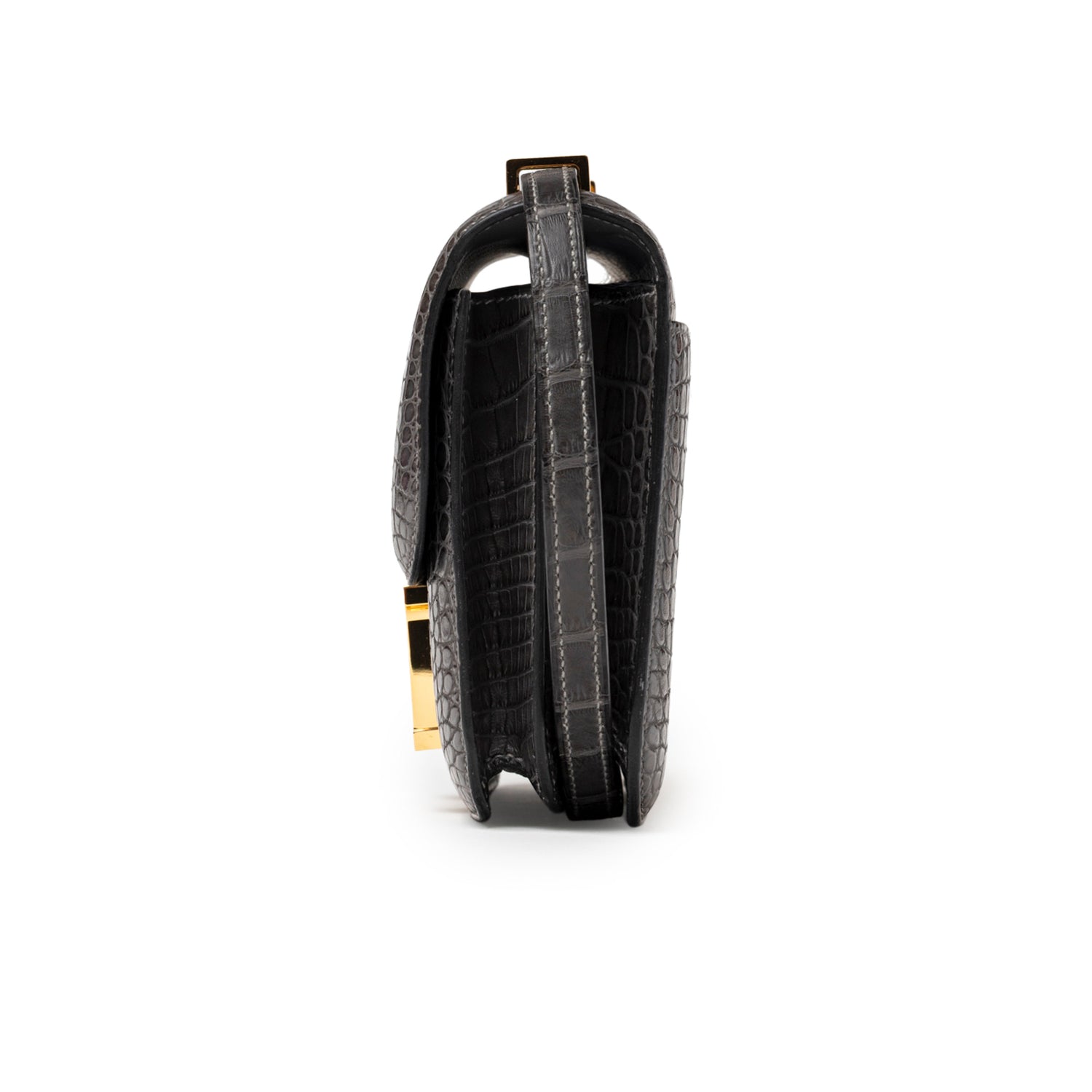 Side profile of Hermès Mini Constance 18 Graphite Matte Alligator Gold Hardware showing textured leather and sleek silhouette