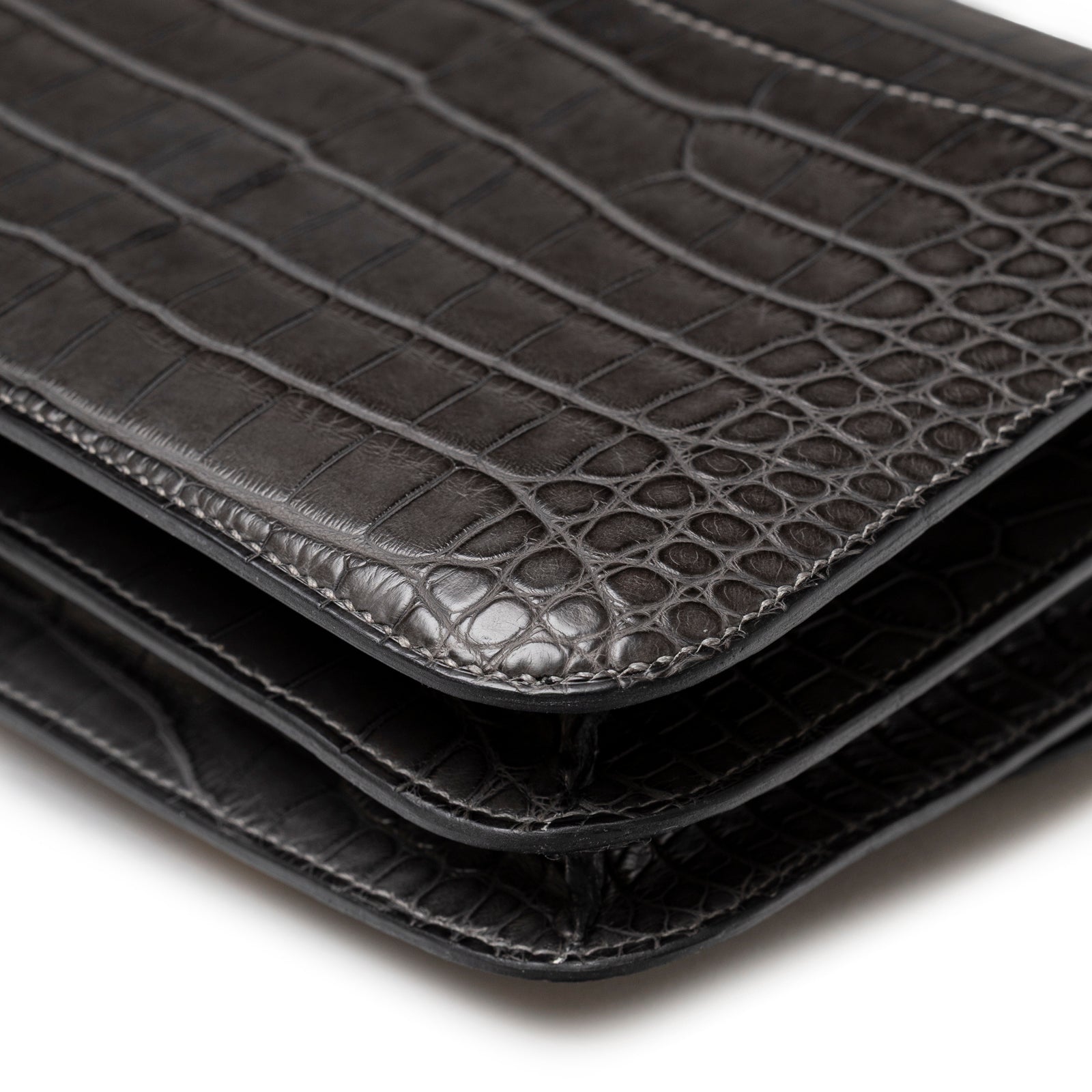 Close-up of corner on Hermès Mini Constance 18 Graphite Matte Alligator Gold Hardware showing layered textured leather