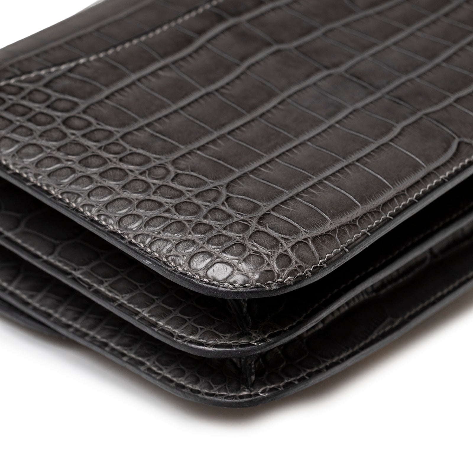 Close-up of corner on Hermès Mini Constance 18 Graphite Matte Alligator Gold Hardware showing sleek layered leather edge