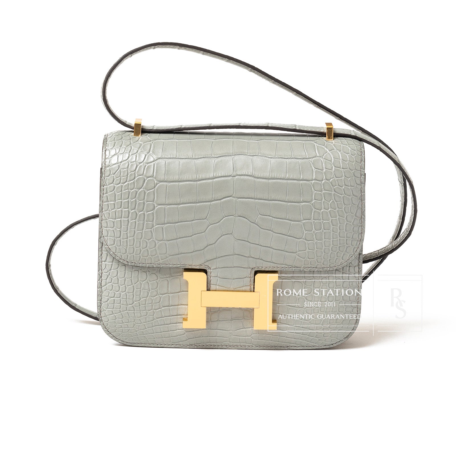 Front view of Hermès Mini Constance 18 Gris Ciment Matte Alligator Gold Hardware with signature H clasp and strap