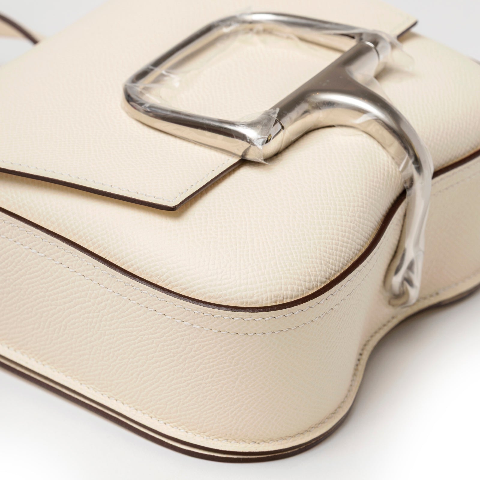 Close-up angled view of Hermès Mini Della Cavalleria Craie Epsom Palladium Hardware showing cream textured leather and polished palladium clasp detail