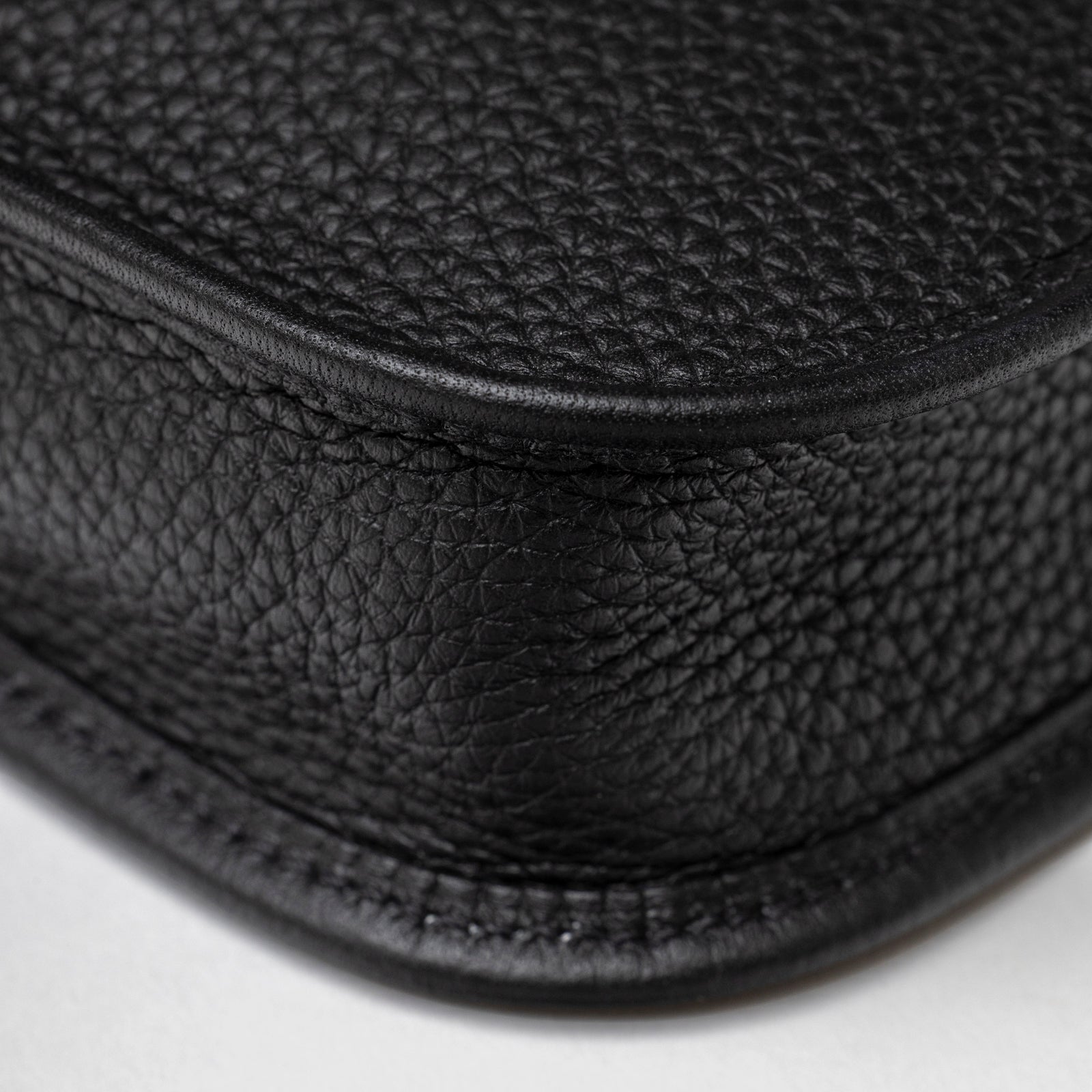 Close-up of Hermès Mini Evelyne Black Clemence Palladium Hardware showing textured leather corner and stitching detail
