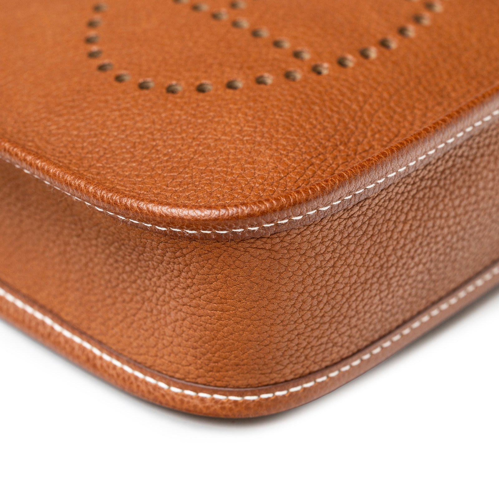 Close-up of Hermès Mini Evelyne Fauve Barenia Palladium Hardware showing leather texture and precise stitching detail.