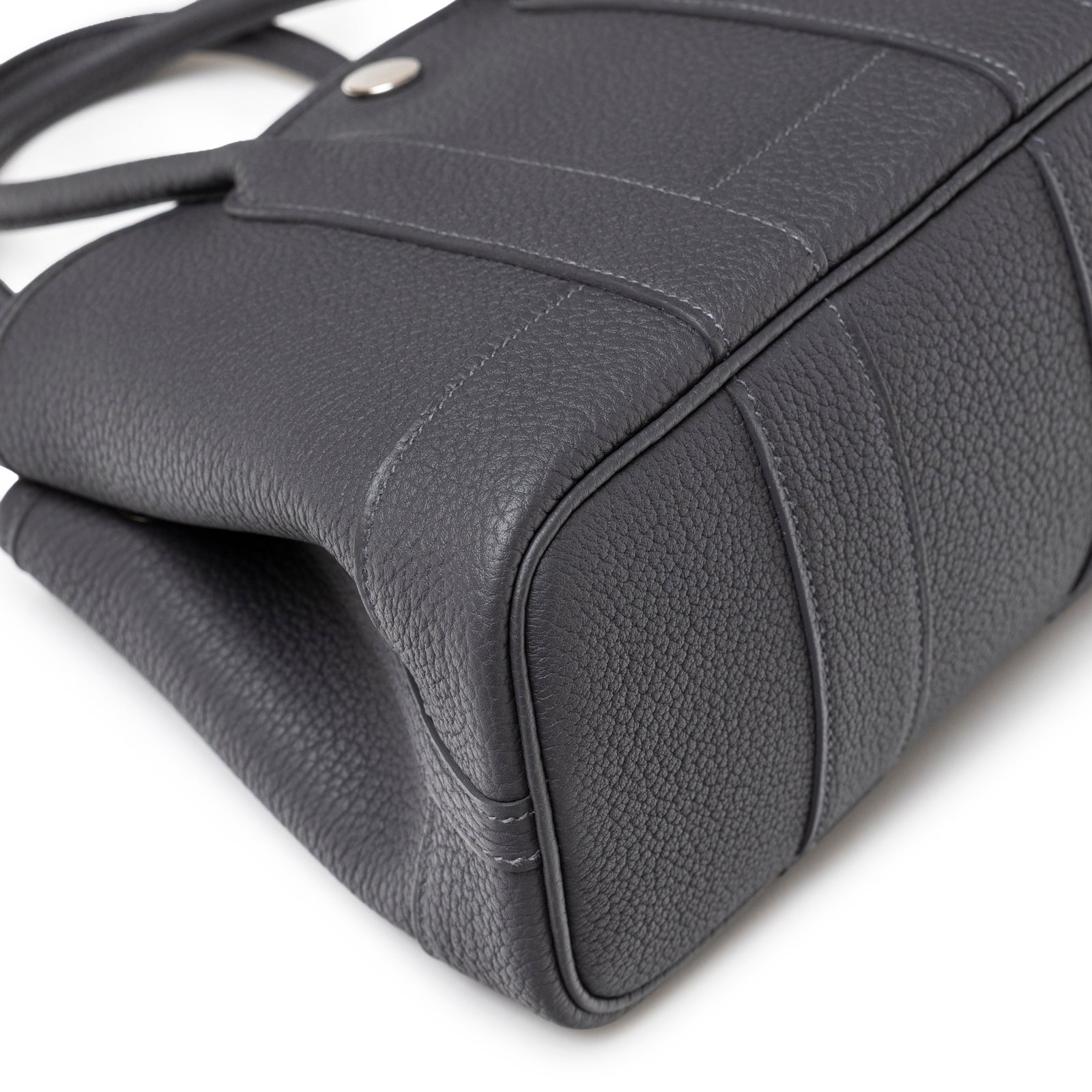Close-up of bottom corner highlighting textured leather and stitching on Hermès Mini Garden Party Neo 23 Ardoise Negonda Palladium Hardware