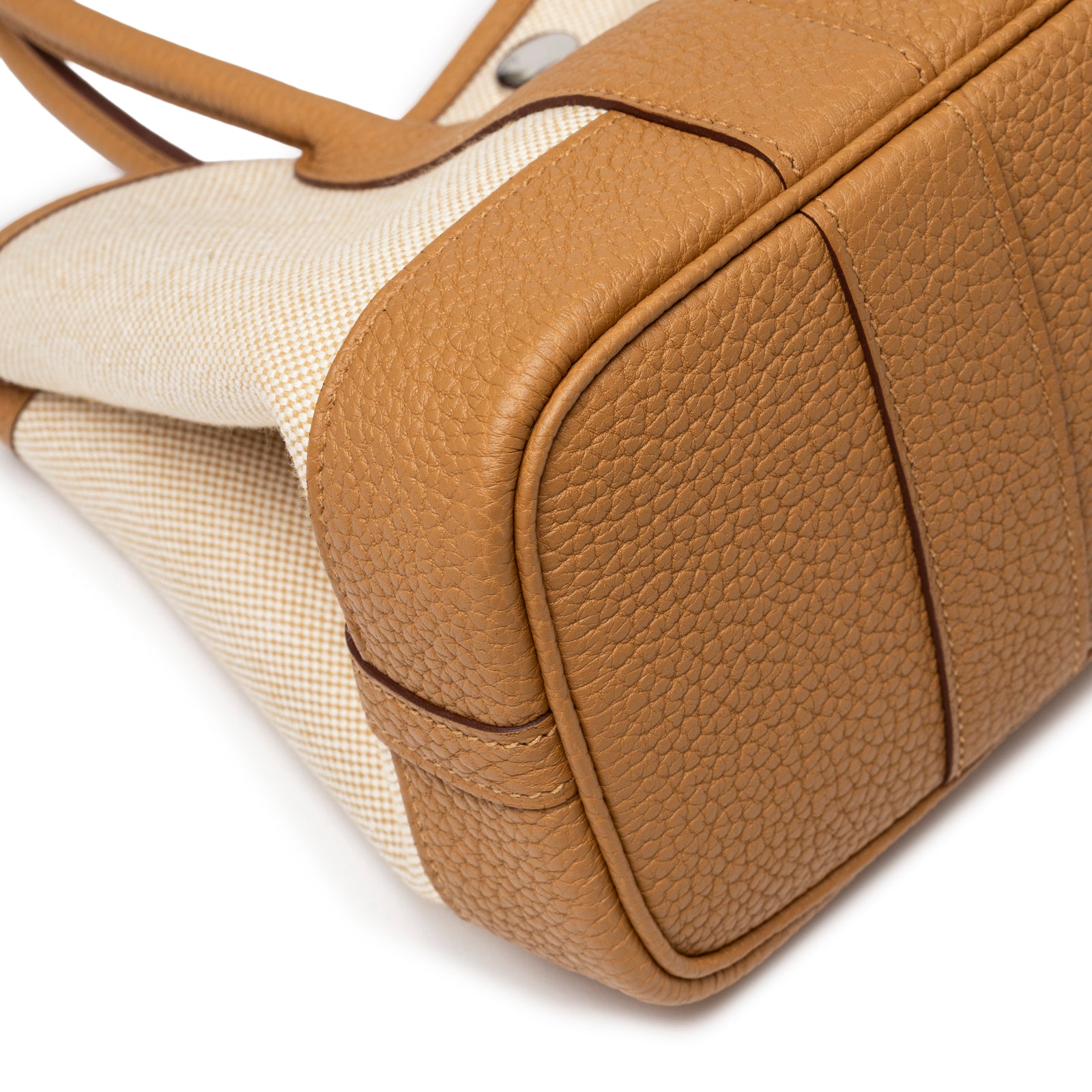 Close-up of textured Sesame Negonda leather bottom corner with Ecru-Paille Toile H Canvas on Hermès Mini Garden Party Neo 23 Ecru-Paille Toile H Canvas and Sesame Negonda Palladium Hardware