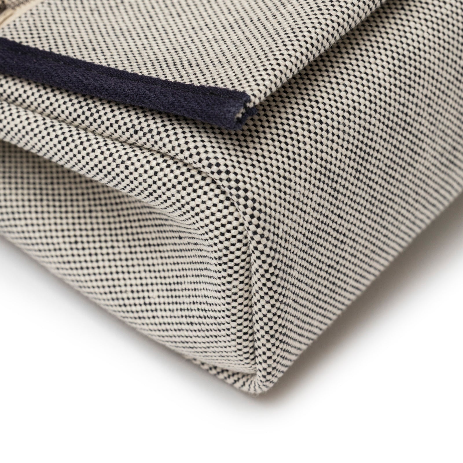 Close-up angled view of Hermès Mini Herbag Zip 20 Ecru-Black Blue Indigo Toile and Vache Hunter Palladium Hardware corner detailing