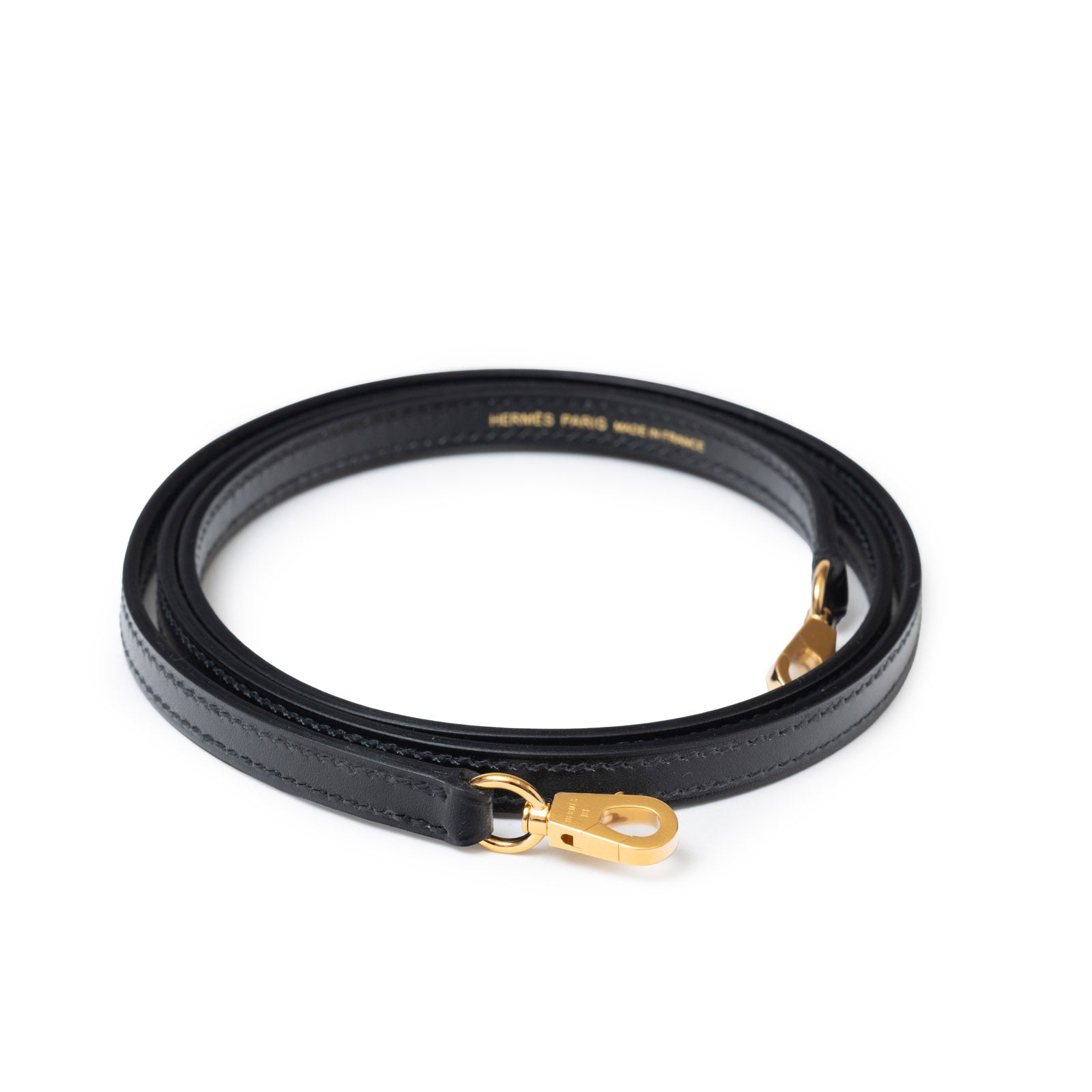 Close-up of Hermès Mini Kelly II Sellier 20 Black Box Gold Hardware leather strap with gold clasp hardware.