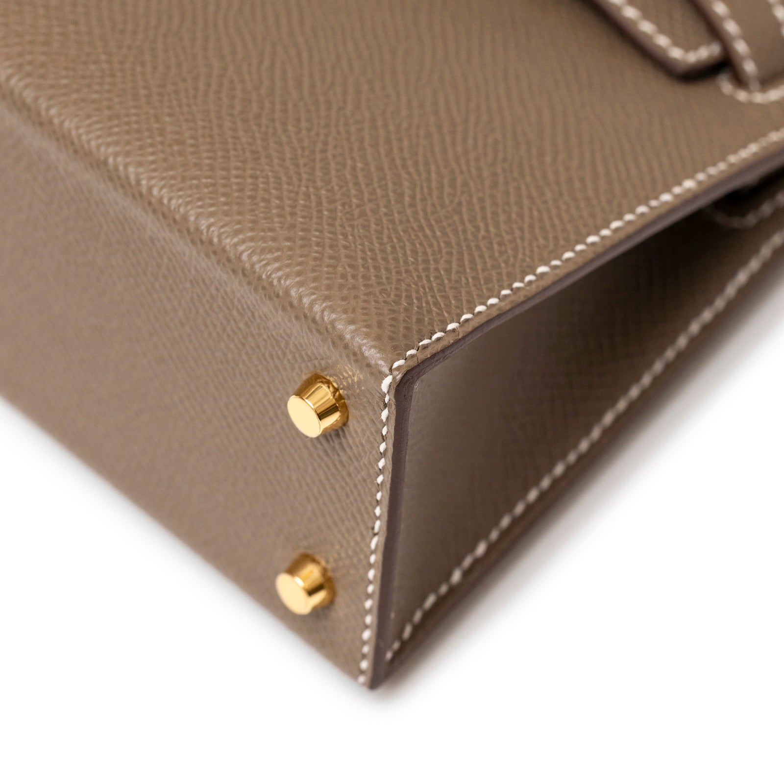 Close-up angled view of Hermès Mini Kelly II Sellier Etoupe Epsom Gold Hardware corner and stitching detail