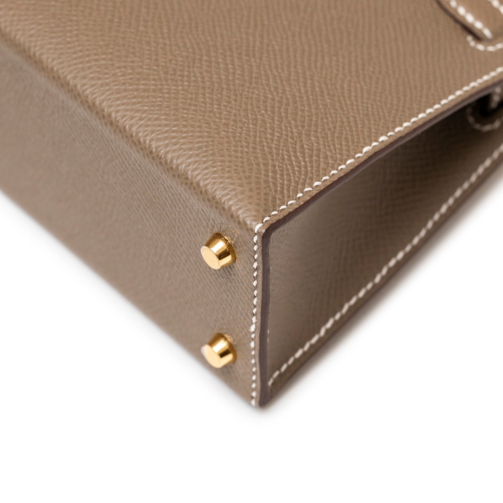 Close-up of the bottom corner showing gold feet and Etoupe Epsom leather stitching on Hermès Mini Kelly II Sellier Etoupe Epsom Gold Hardware