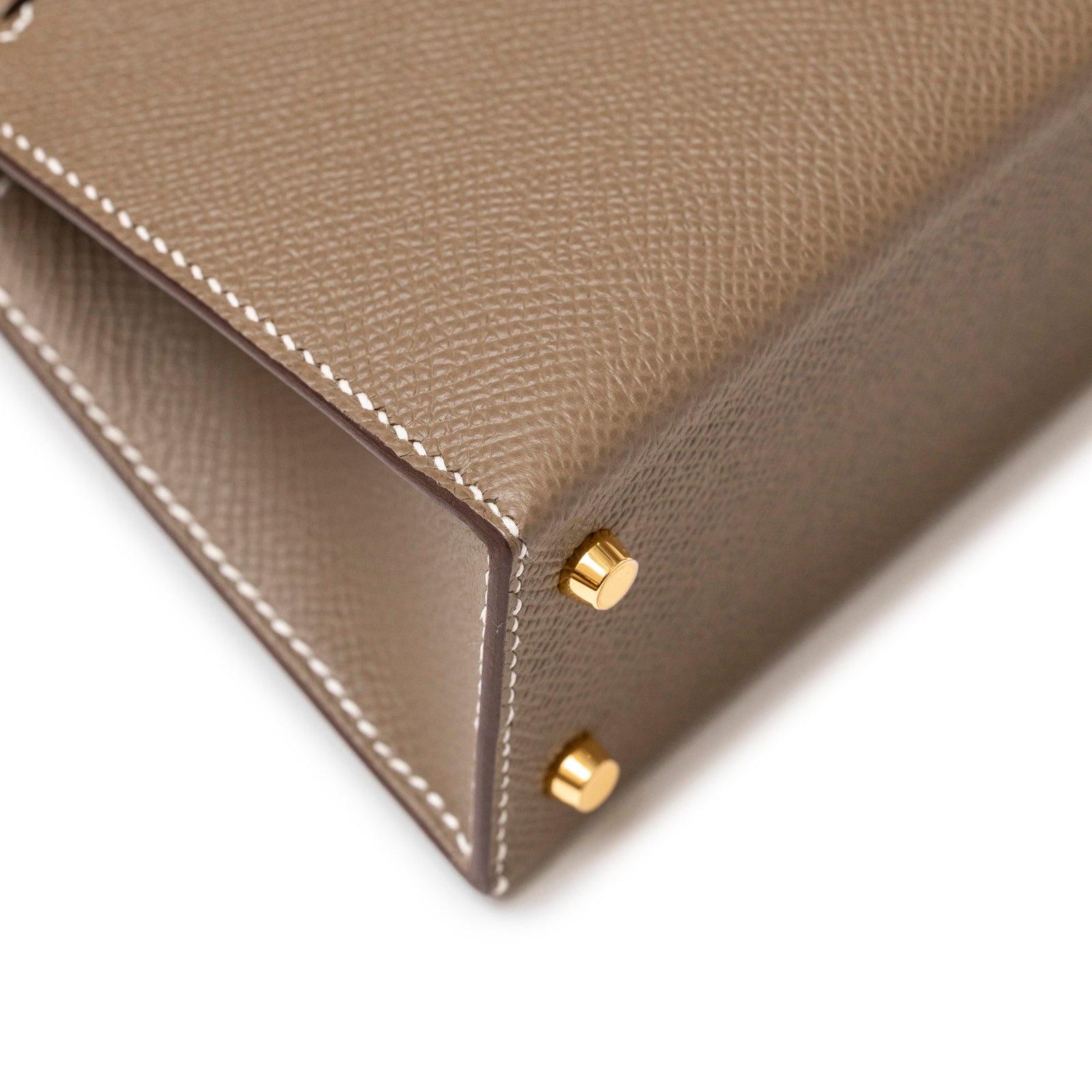 Close-up of corner with white stitching and gold hardware feet on Hermès Mini Kelly II Sellier Etoupe Epsom Gold Hardware