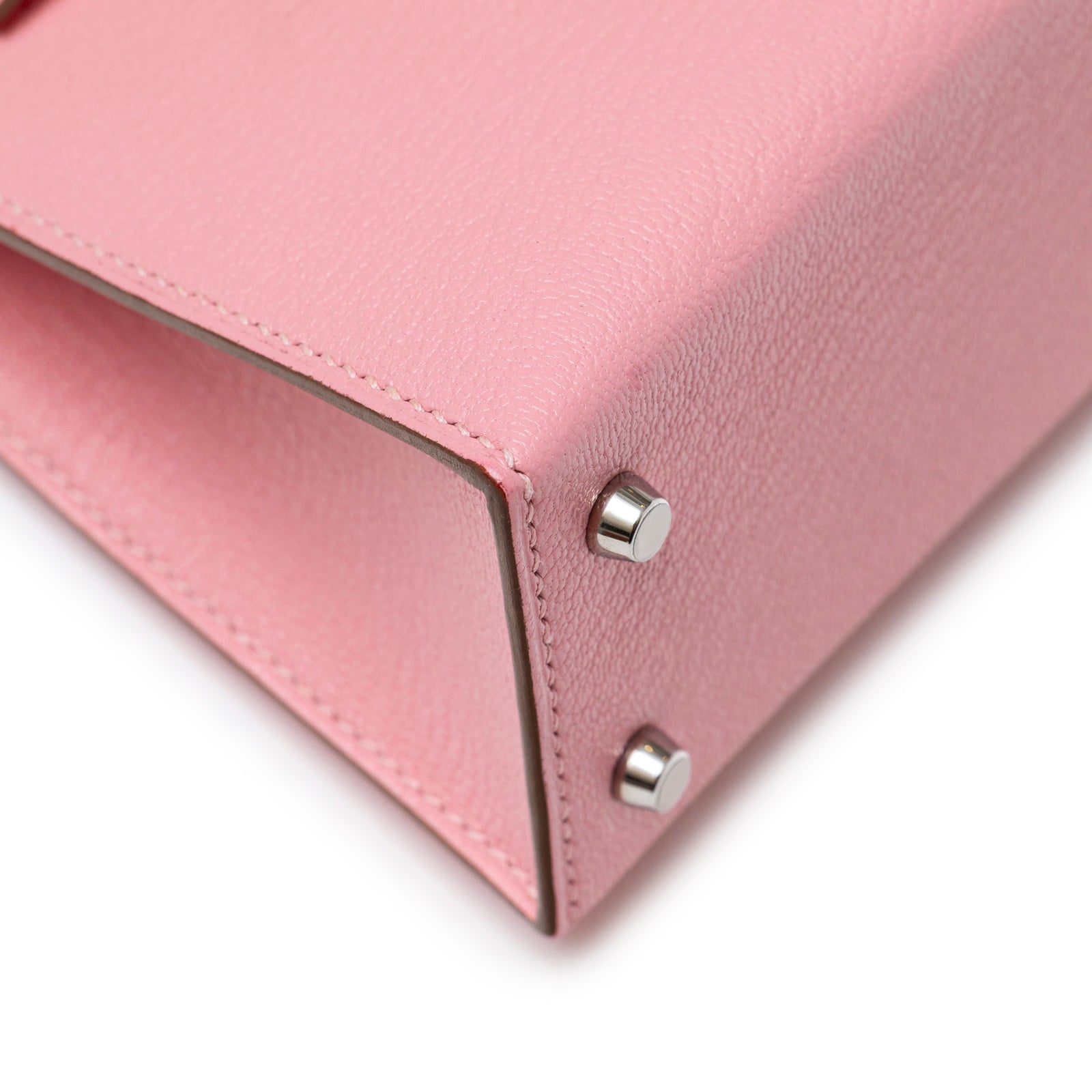 Close-up of bottom corner showing texture and palladium feet on Hermès Mini Kelly II Sellier Rose Confetti Chevre Mysore Palladium Hardware