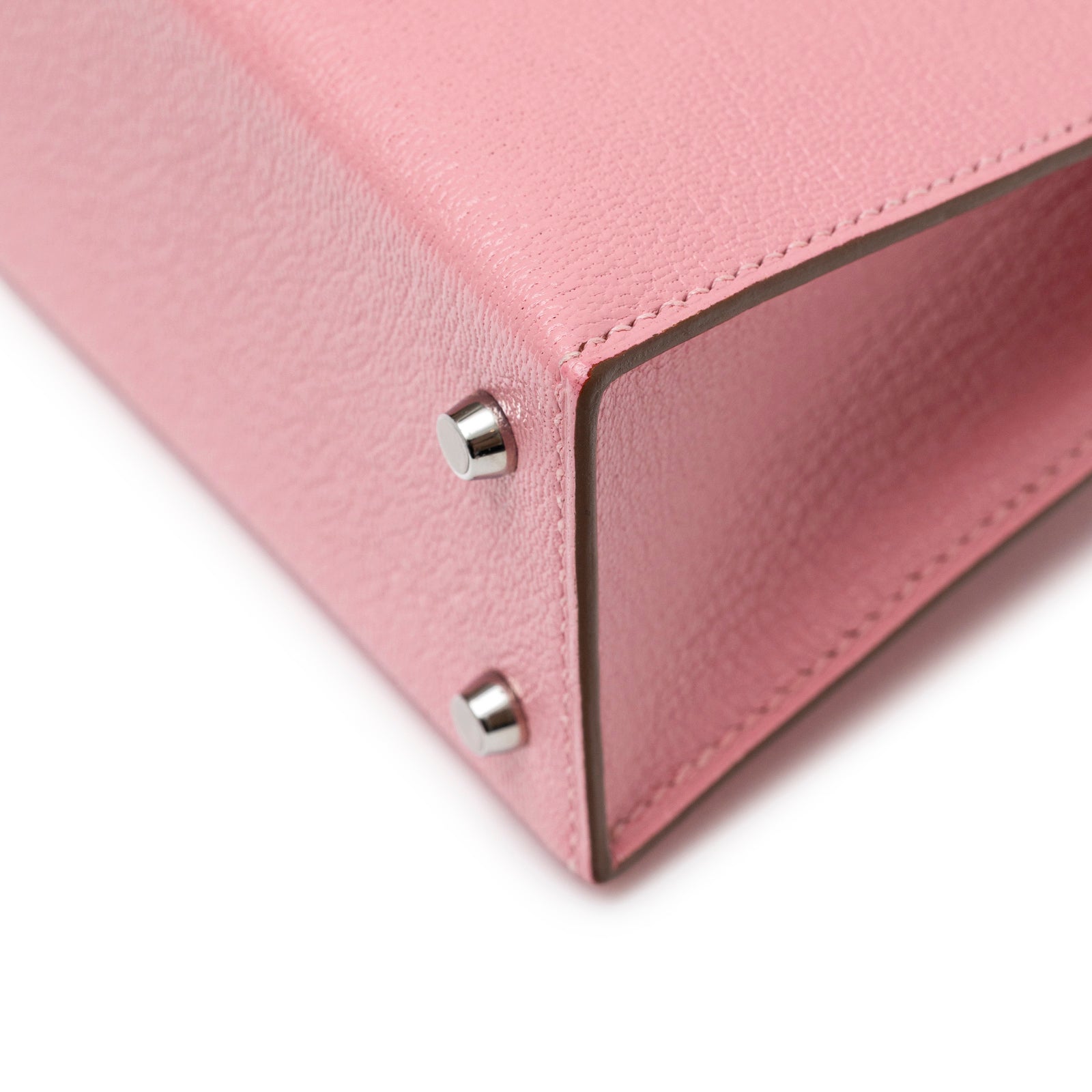 Close-up of bottom corner showing pink leather texture and palladium hardware on Hermès Mini Kelly II Sellier Rose Confetti Chevre Mysore Palladium Hardware