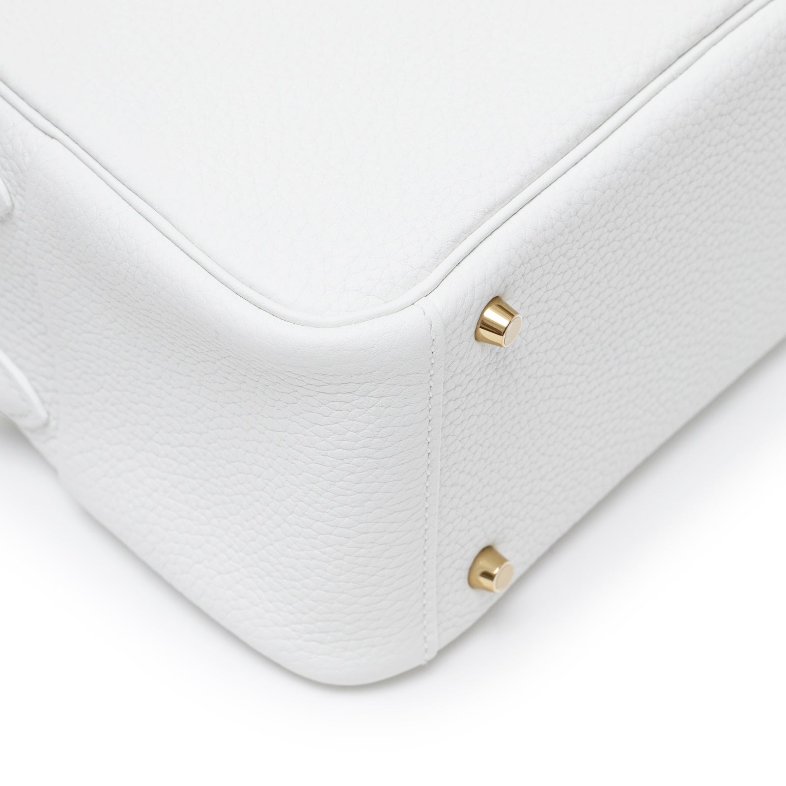 Close-up of bottom corner and gold hardware feet on Hermès Mini Lindy II New White Clemence Gold Hardware bag