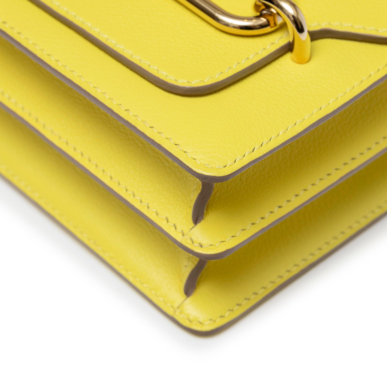 Close-up angled shot of Hermès Mini Roulis Lime Evercolor Permabrass Hardware showing leather edges and stitching details