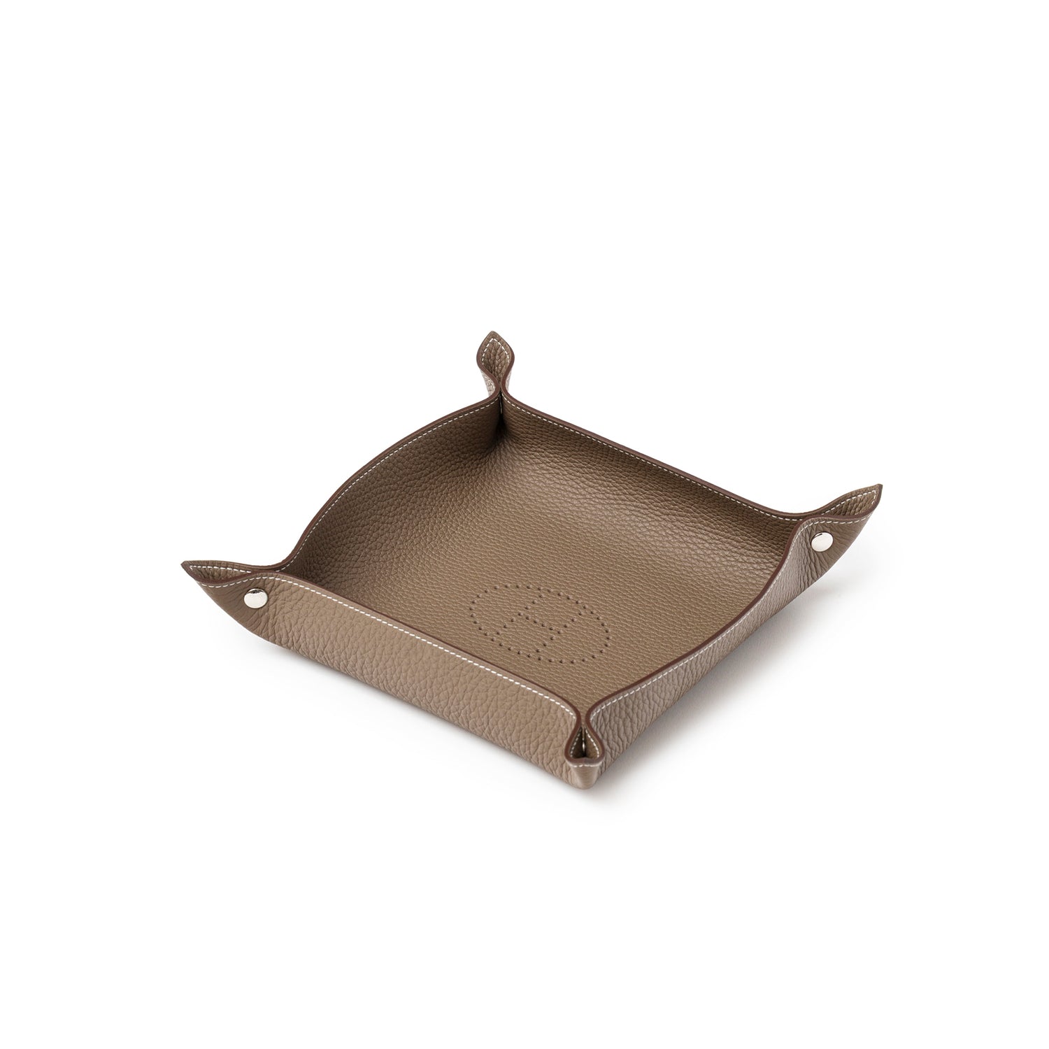 Angled view of Hermès Mises et Relances H Evelyne Change Tray Etoupe Clemence in textured leather with snap corners