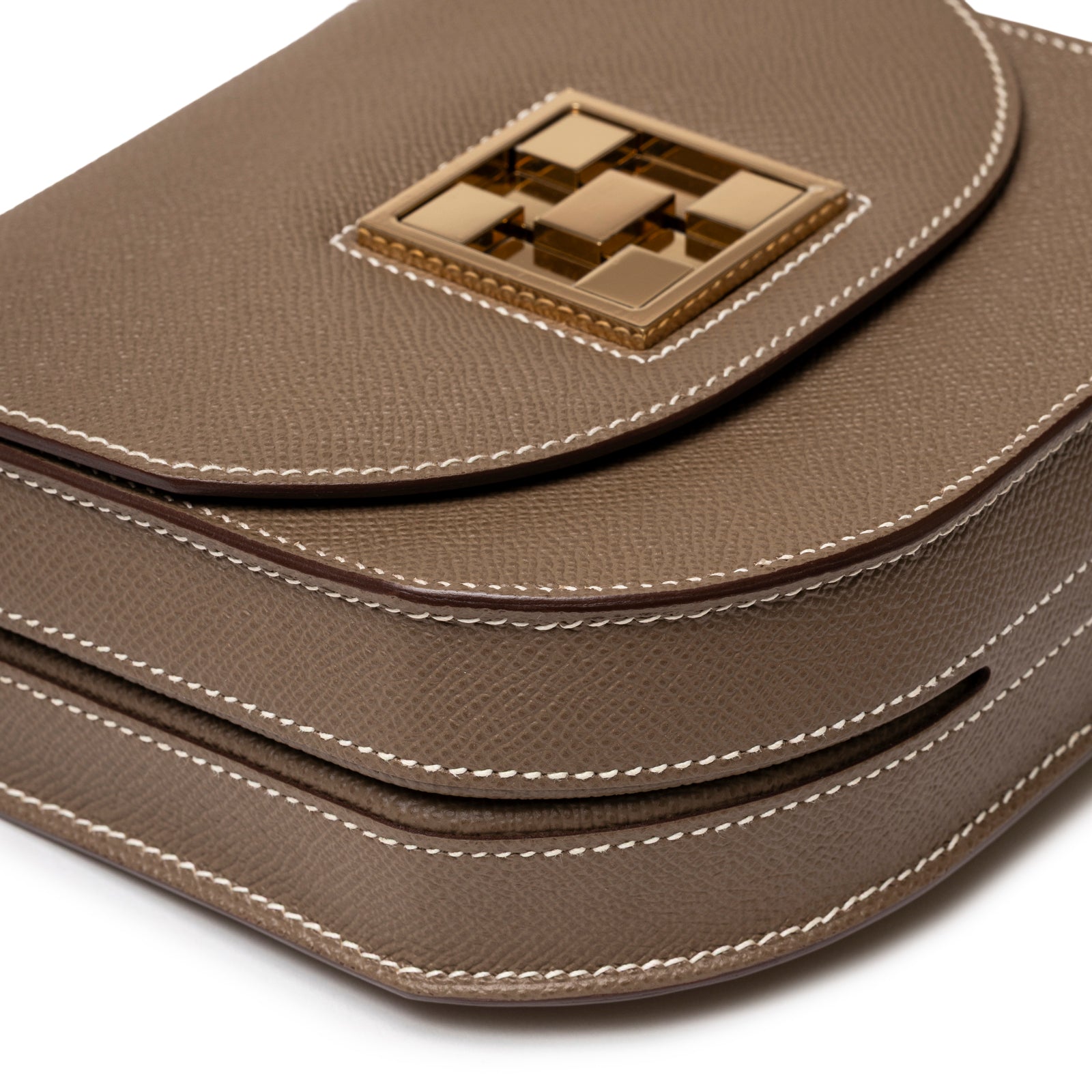 Close-up angled view of Hermès Mosaique Au 24-17 Etoupe Epsom Permabrass Hardware showing textured leather and gold clasp detail