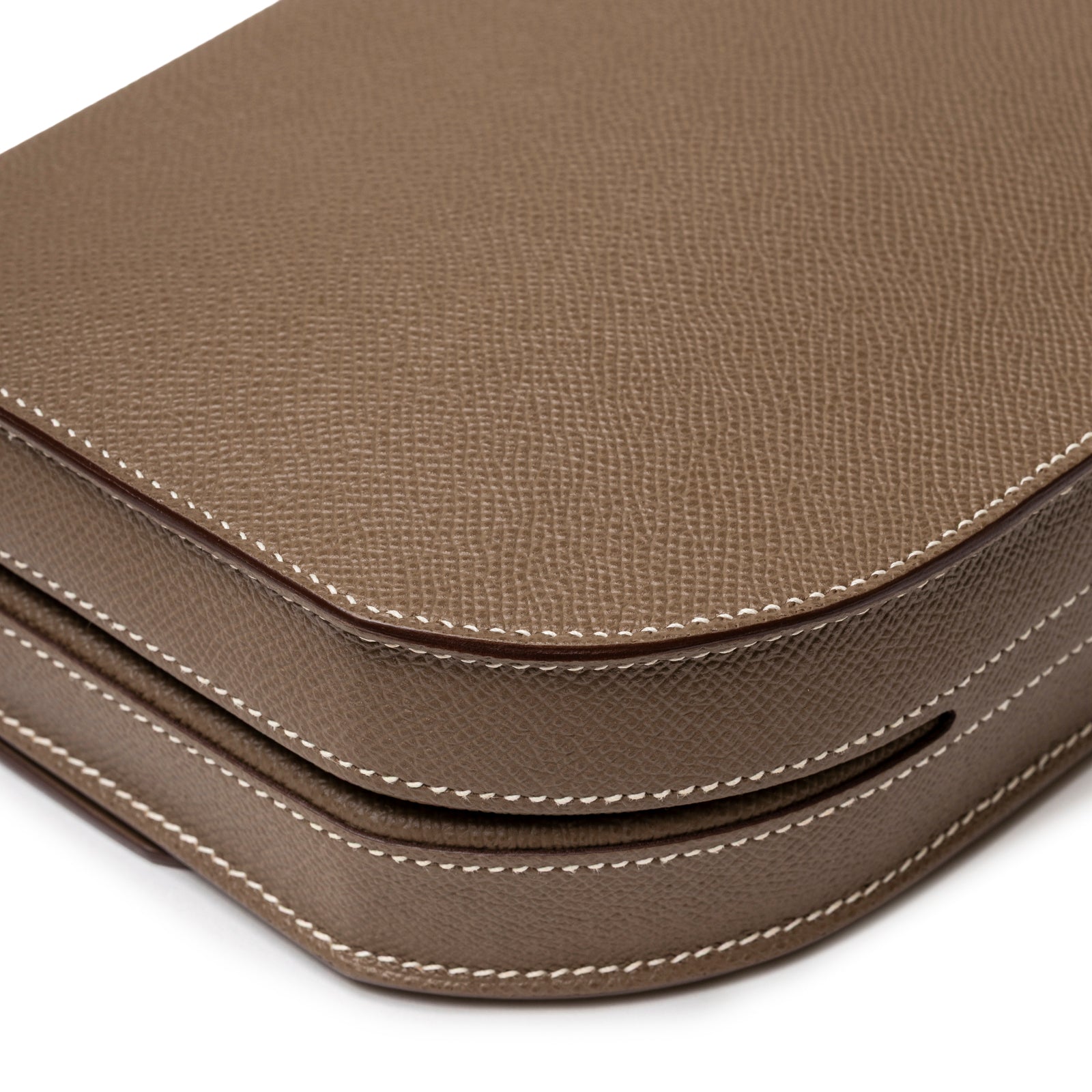Close-up angled shot of Hermès Mosaique Au 24-17 Etoupe Epsom Permabrass Hardware showing leather texture and edge stitching detail