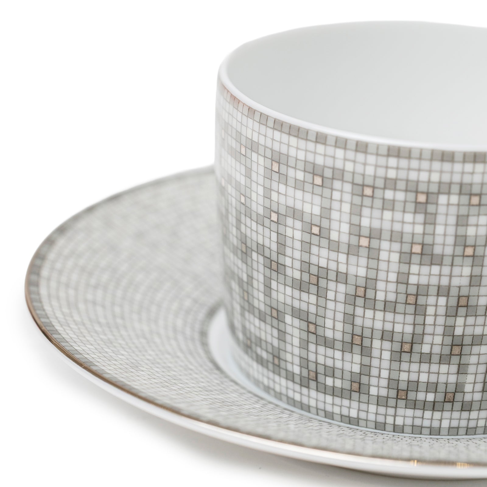 Close-up angled view of Hermès Mosaique au 24 Platinum Tea Cup & Saucer Set of Two with mosaic platinum pattern