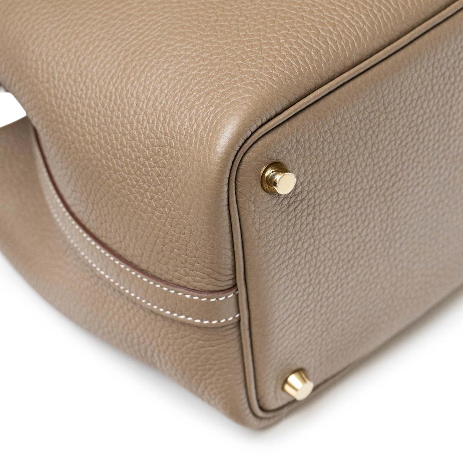 Close-up of Hermès Picotin 18 Etoupe Clemence Gold Hardware showing textured leather and gold studs on the bag corner.