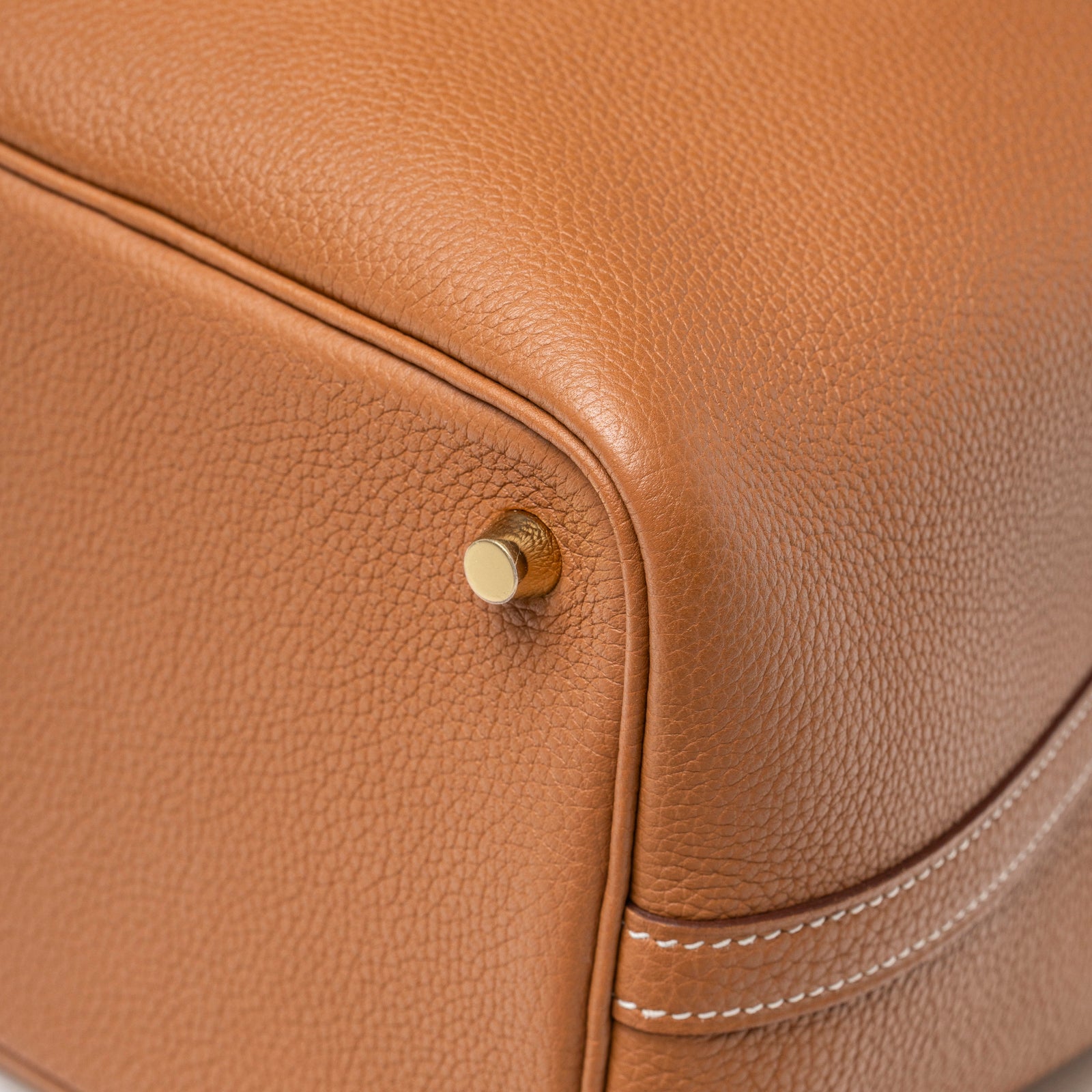 Close-up bottom corner of Hermès Picotin 18 Gold Clemence Gold Hardware showing leather texture and gold foot detail