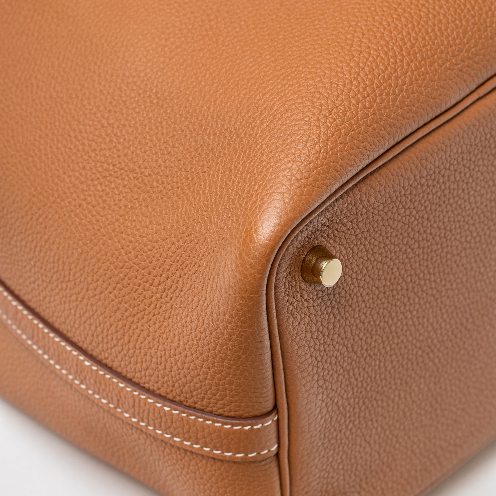 Close-up of Hermès Picotin 18 Gold Clemence Gold Hardware D bag corner showing textured leather and gold foot stud detail
