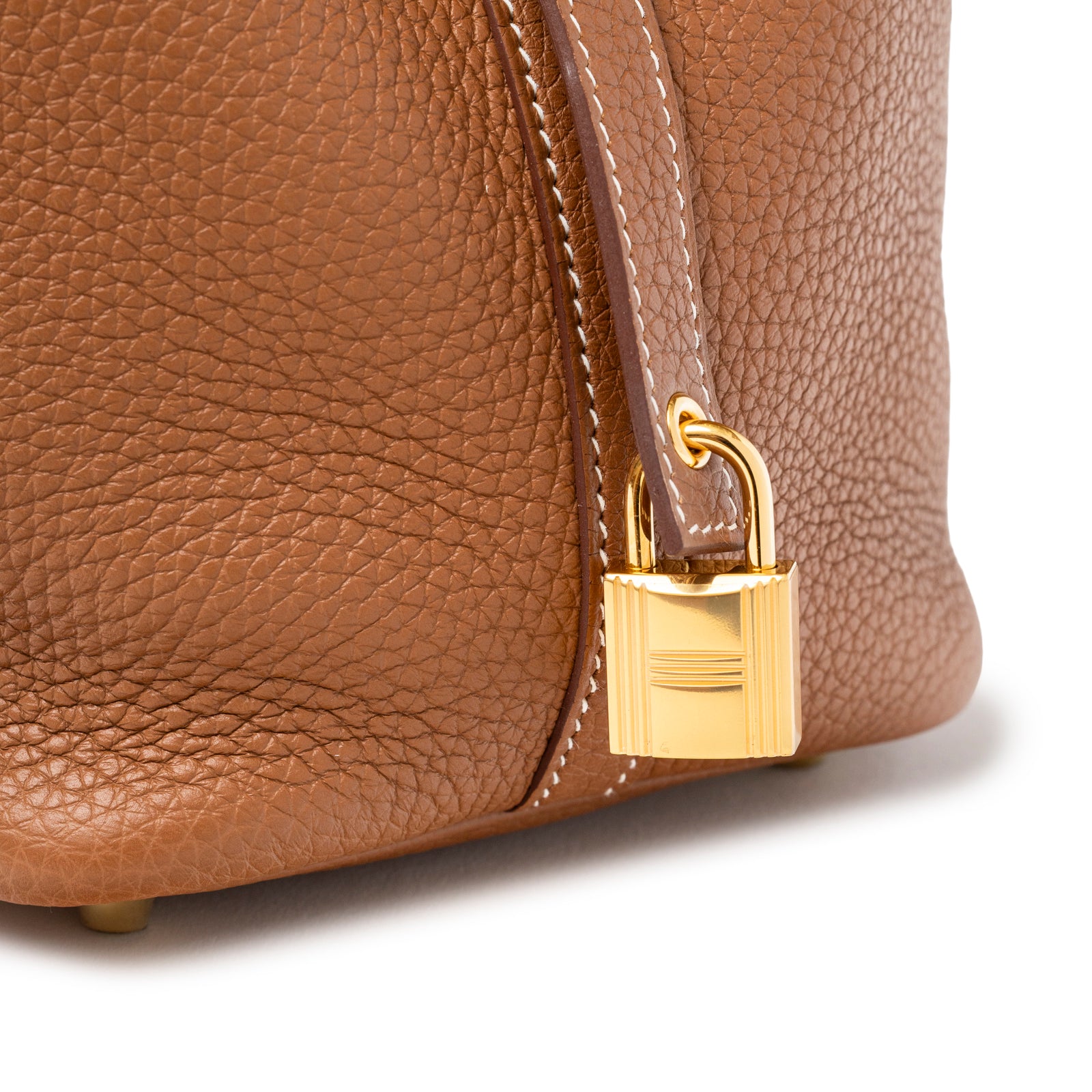 Close-up of tan textured leather and gold lock detail on Hermès Picotin 18 Gold Clemence Gold Hardware